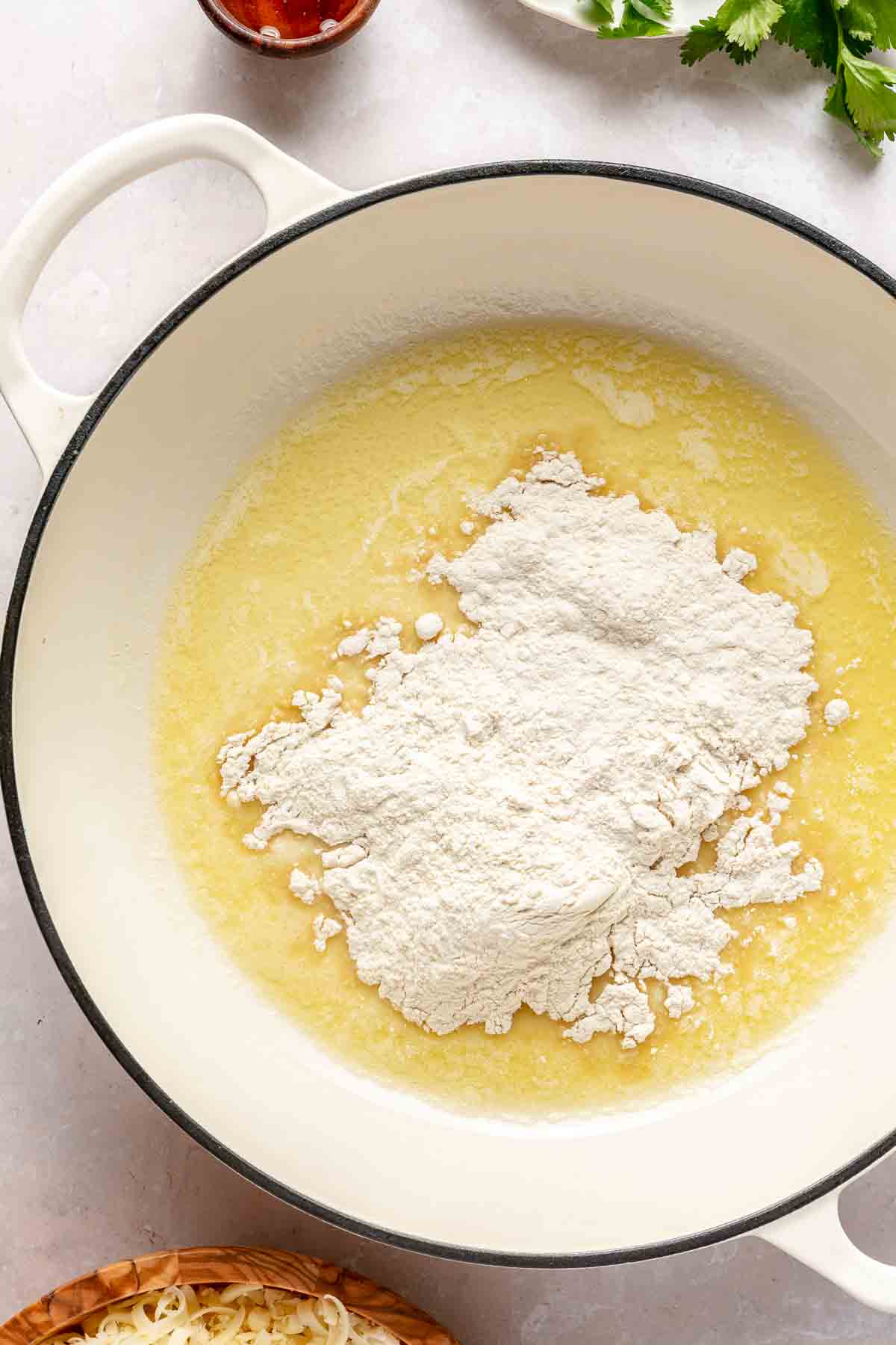 Mixing flour with melted butter in a pot.