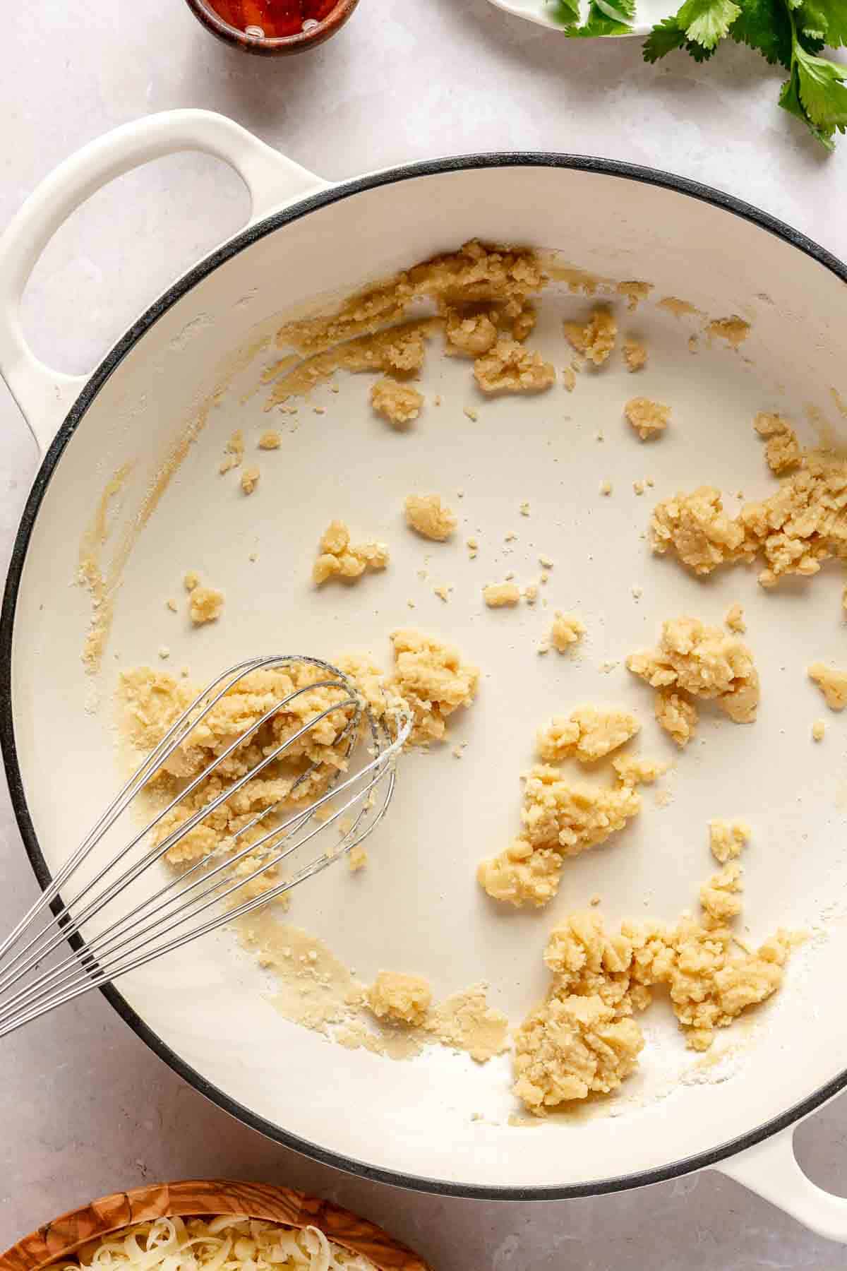 Whisking flour with melted butter.