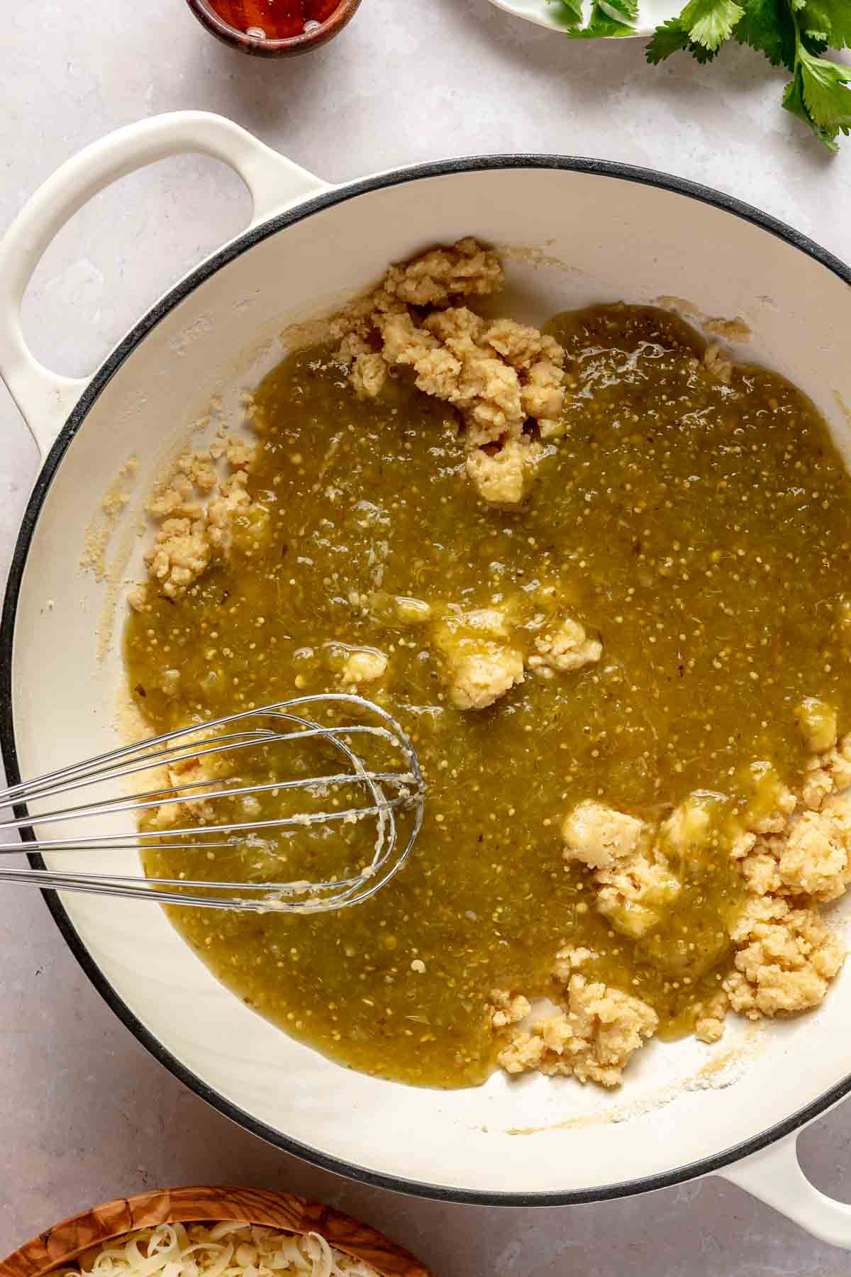 Whisking salsa verde with flour and butter mixture.