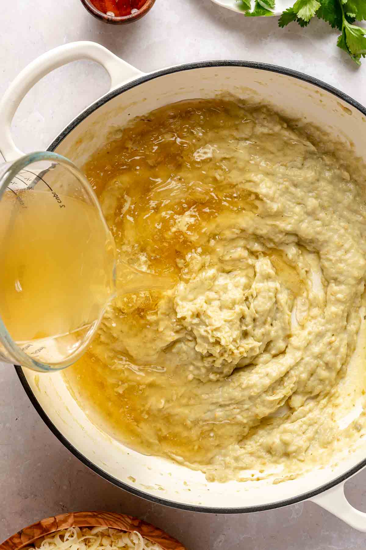 Pour chicken broth into salsa verde mixture.