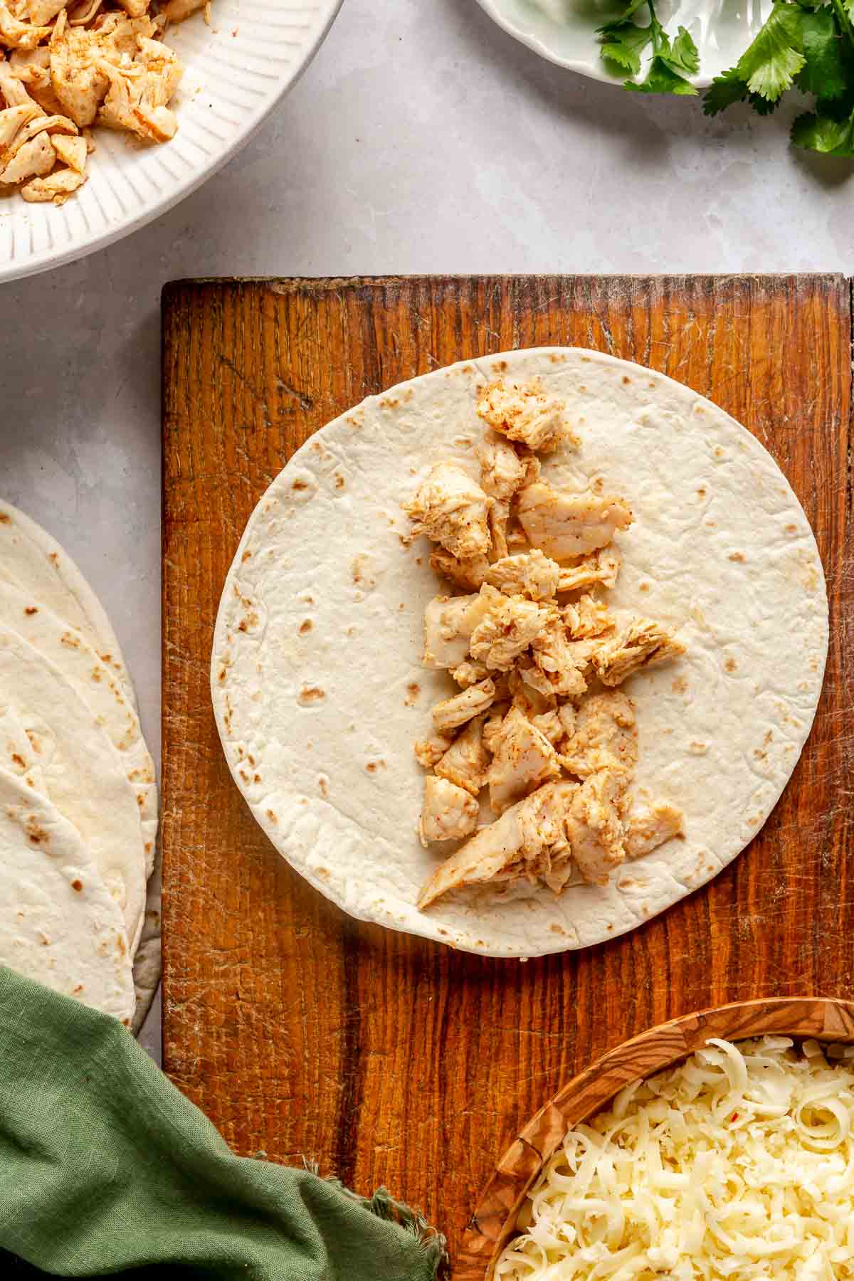 Shredded chicken on a flour tortilla.