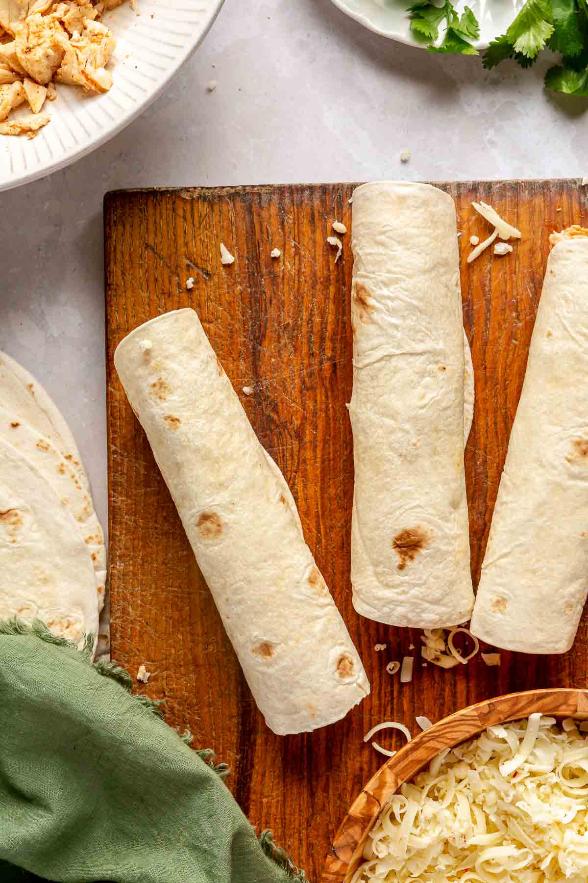 Tortillas rolled up with shredded chicken and cheese.