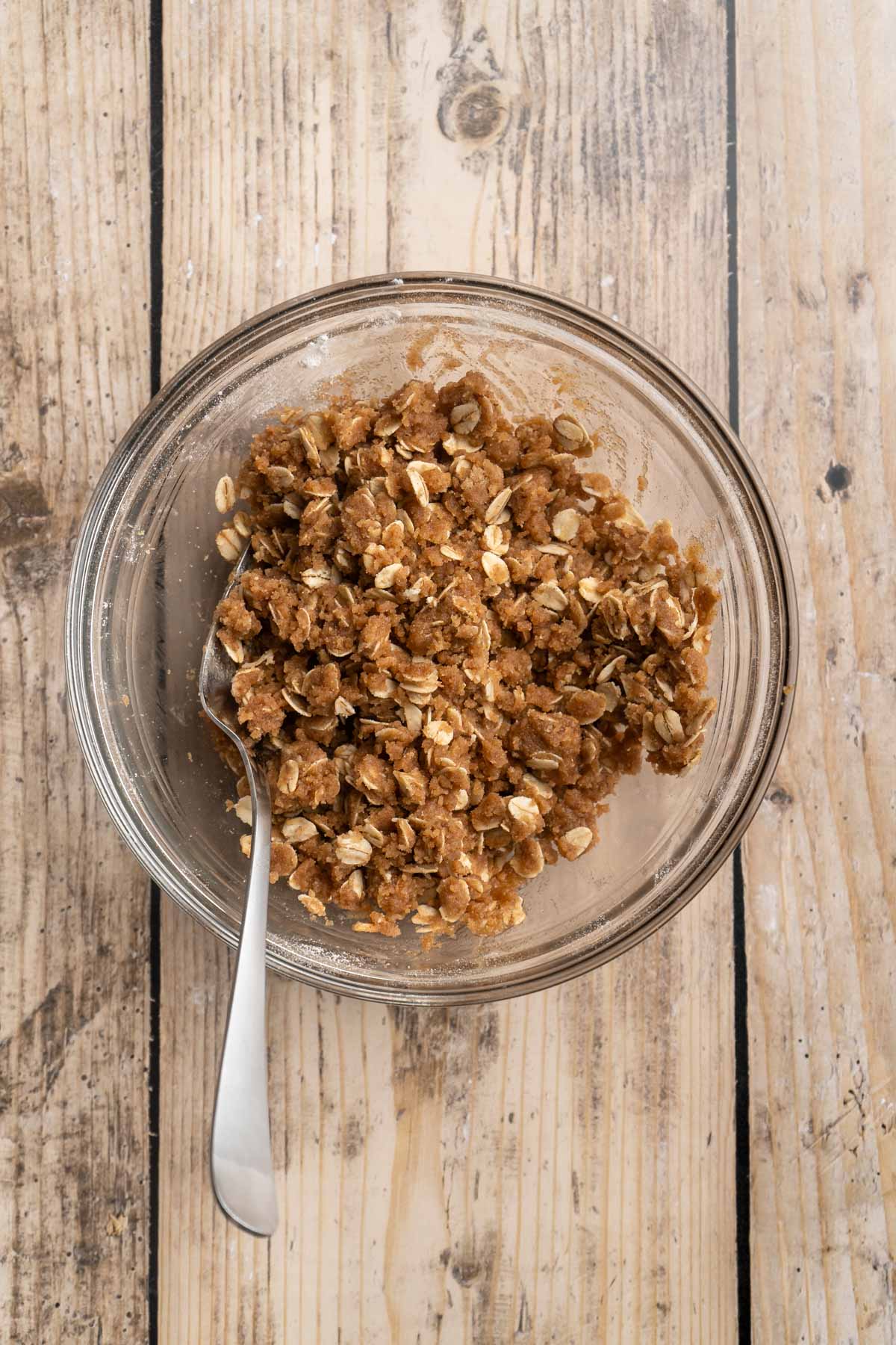 Stirring oats with flour, brown sugar and melted butter.