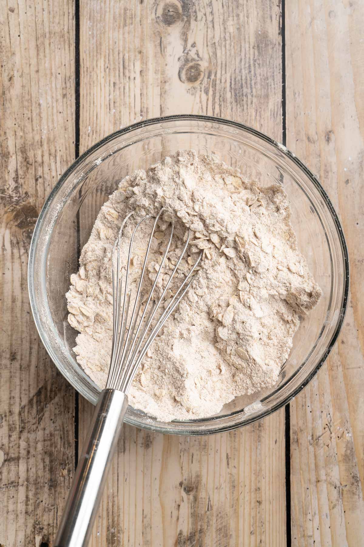 Whisking together oats with flour, cinnamon, baking powder and baking soda.