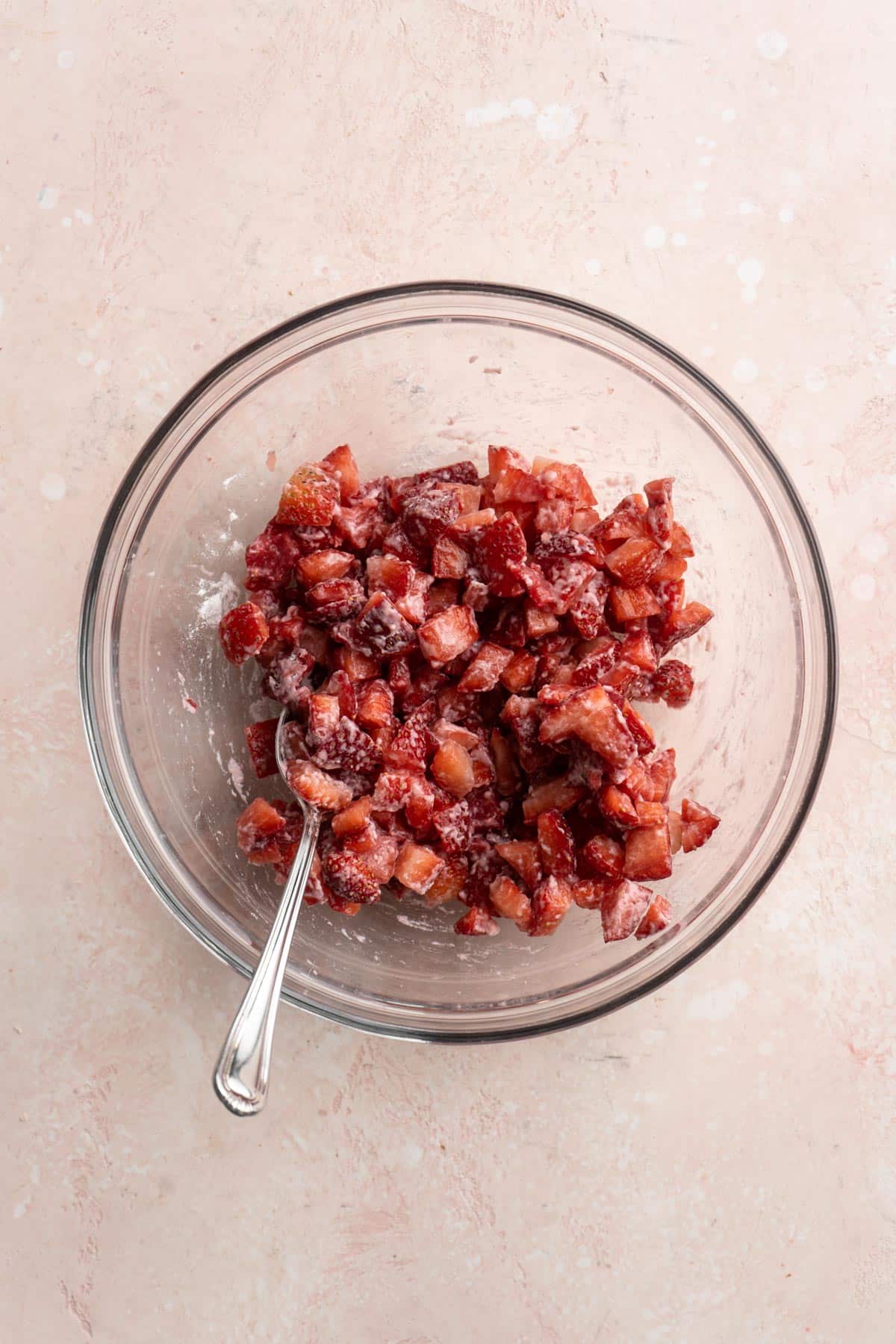 Tossing diced strawberries with flour.