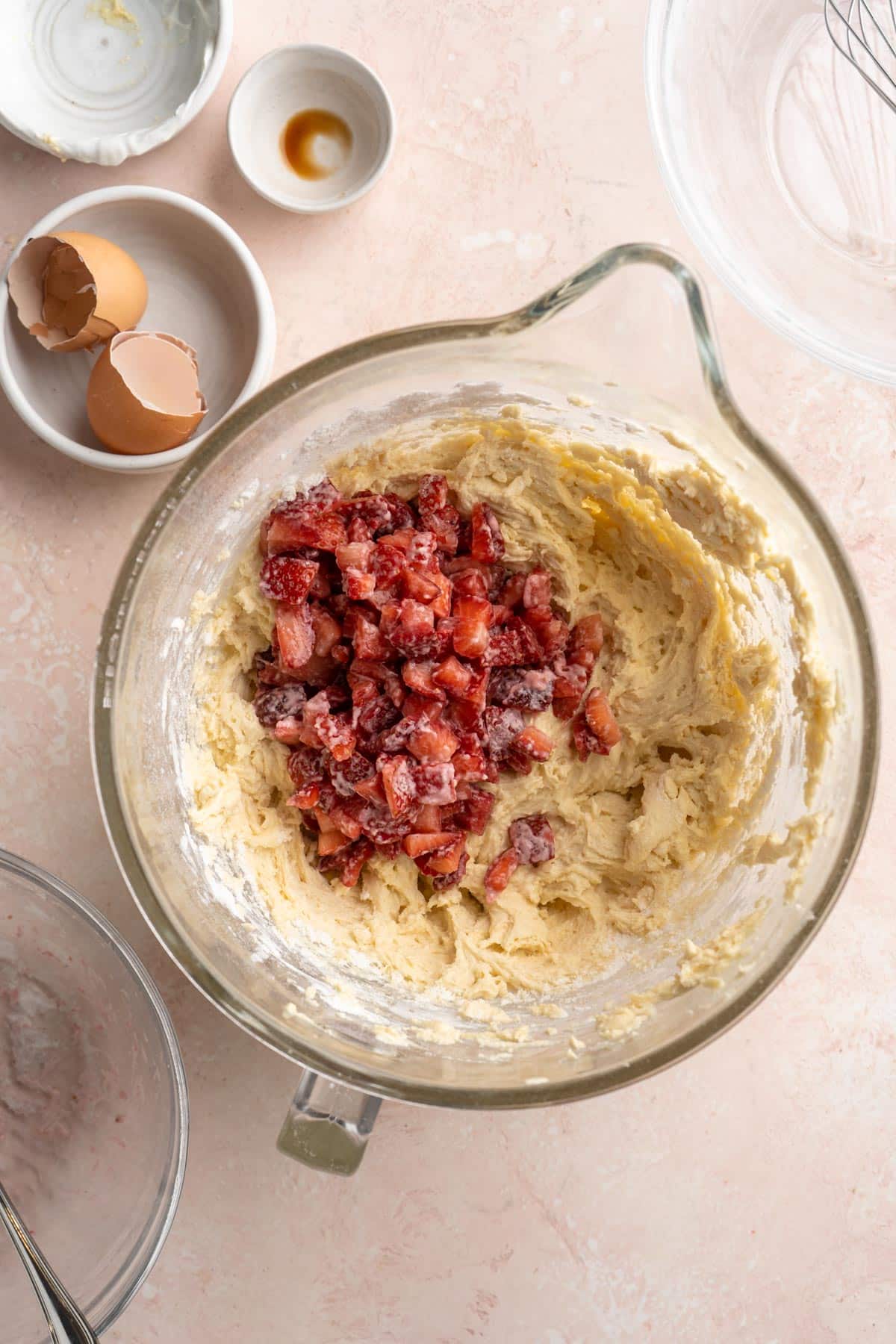 Adding strawberries to batter in a large bowl.