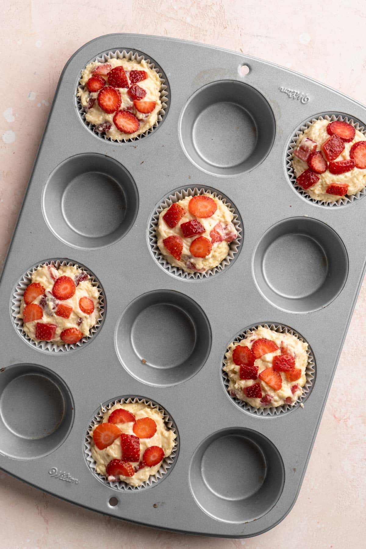 Muffin batter in muffin pan before baking.