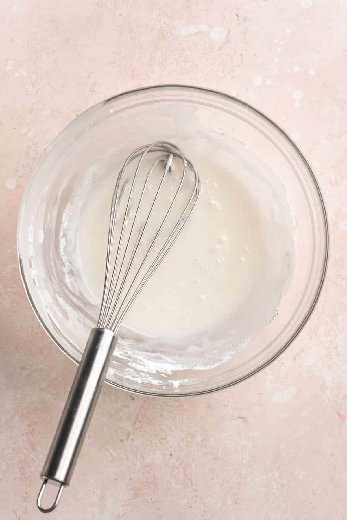 Whisking the glaze in a small mixing bowl.