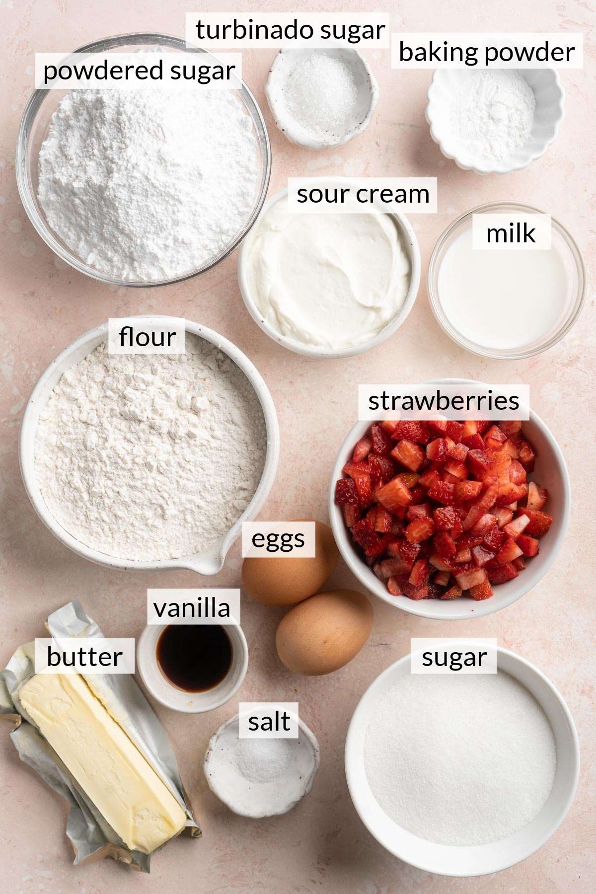 Butter with bowls of chopped strawberries, vanilla, sugar, flour and sour cream.