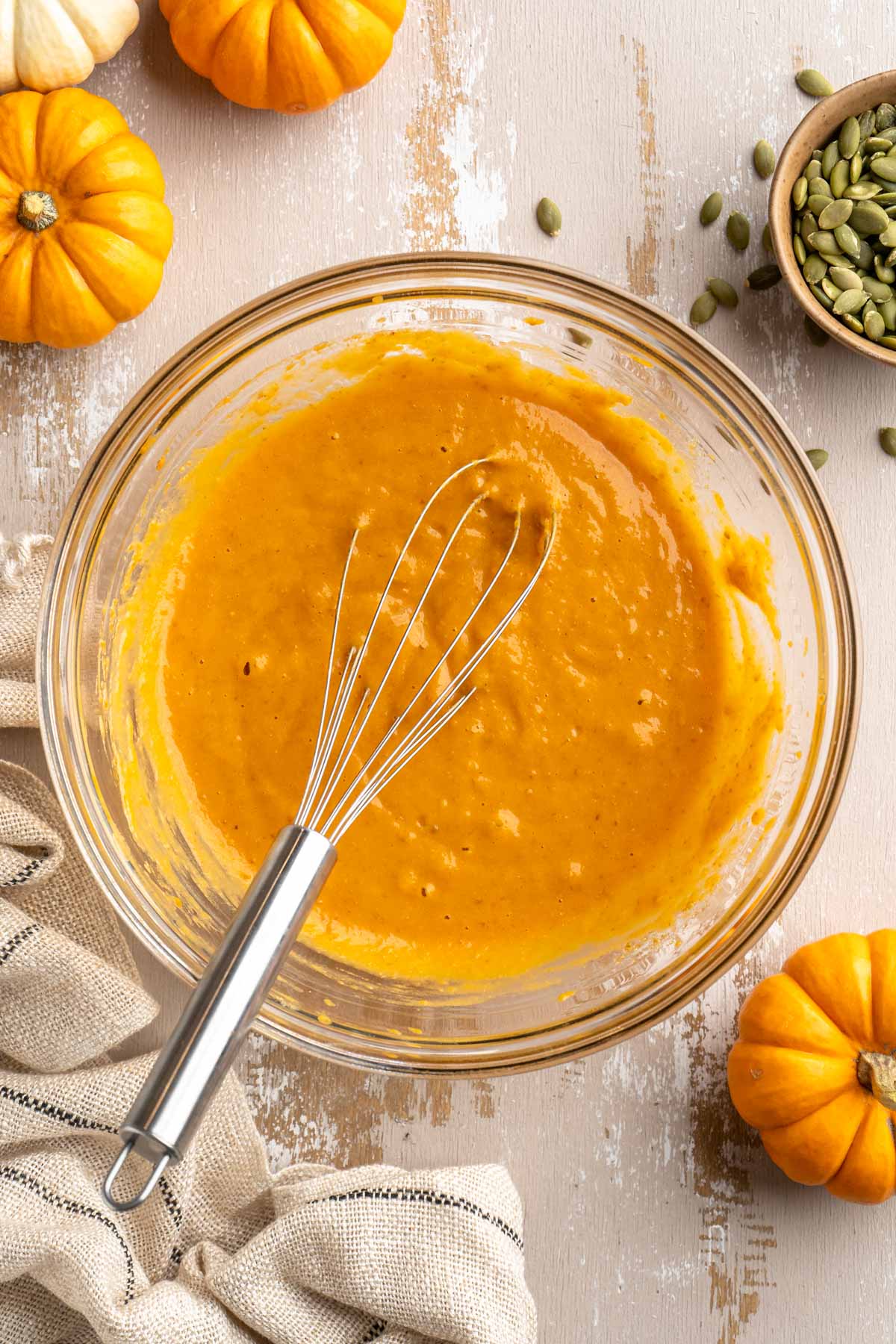 Whisking pumpkin puree with oil, milk and vanilla.