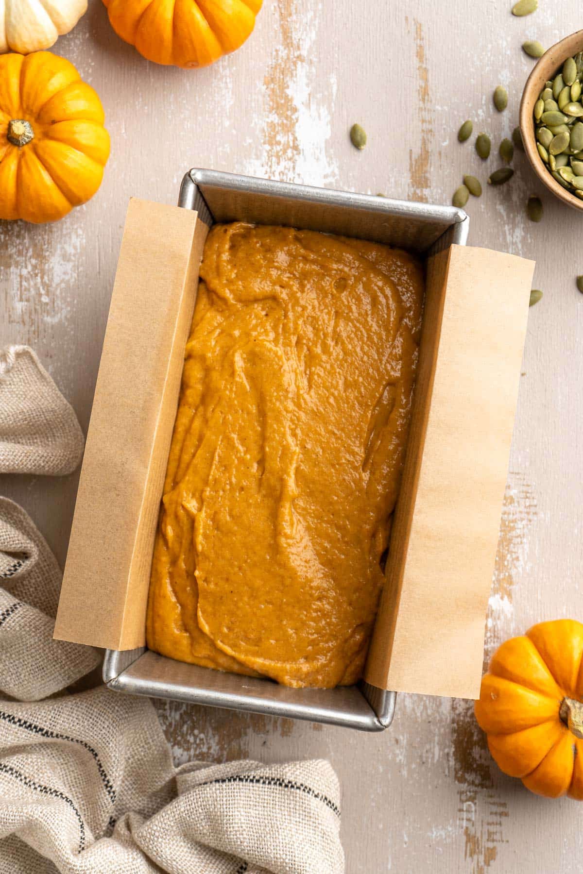 Pumpkin batter in a parchment lined loaf pan.