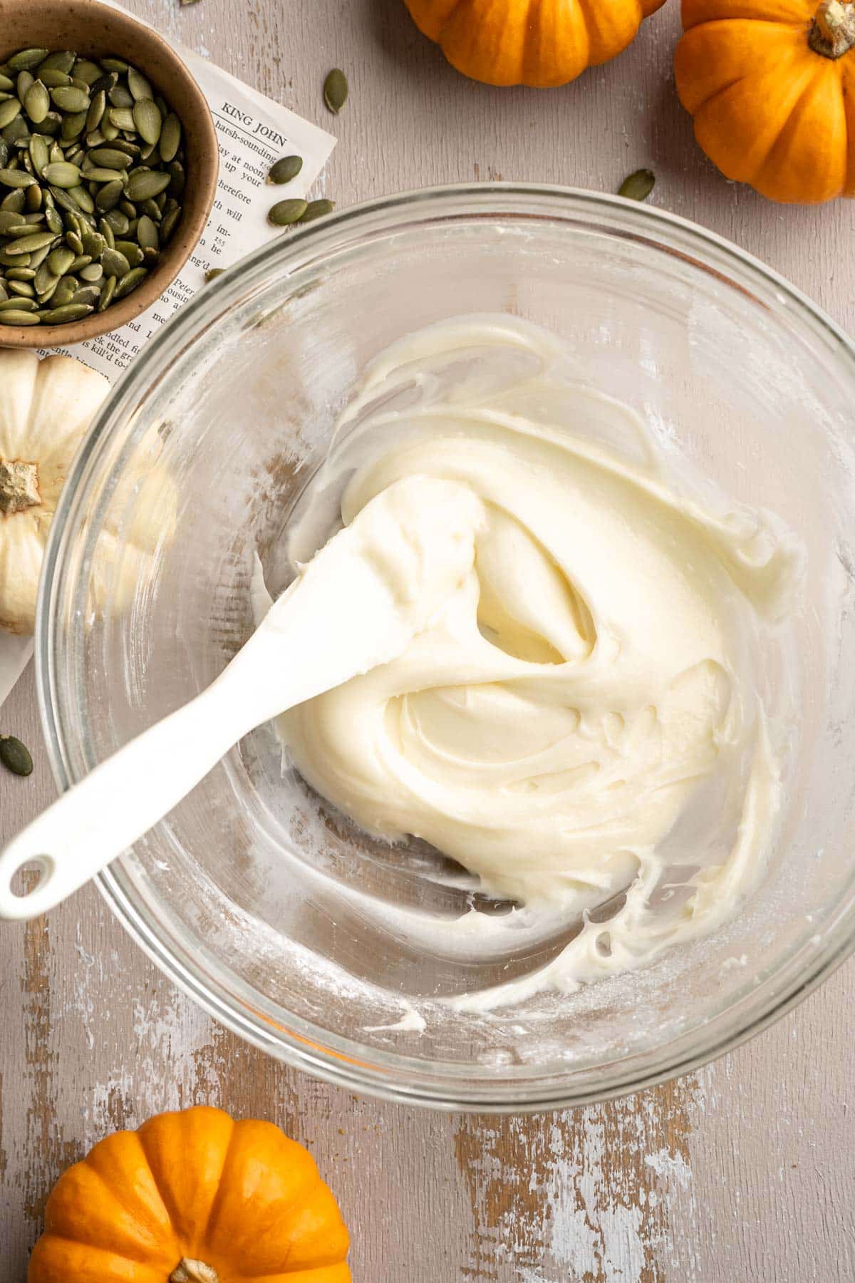 Stirring together cream cheese frosting in a small bowl.