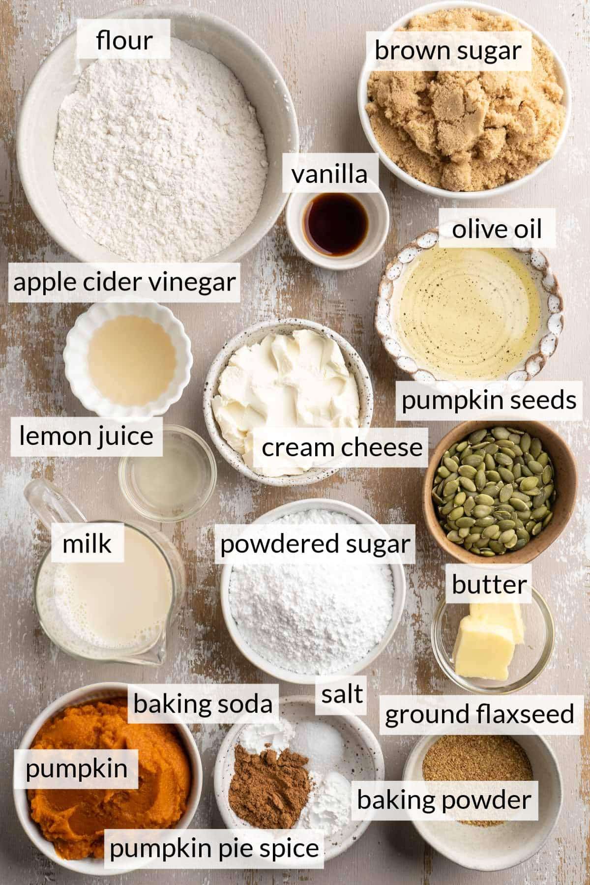 Small bowls with flour, brown sugar, oil, cream cheese, pumpkin and spices.