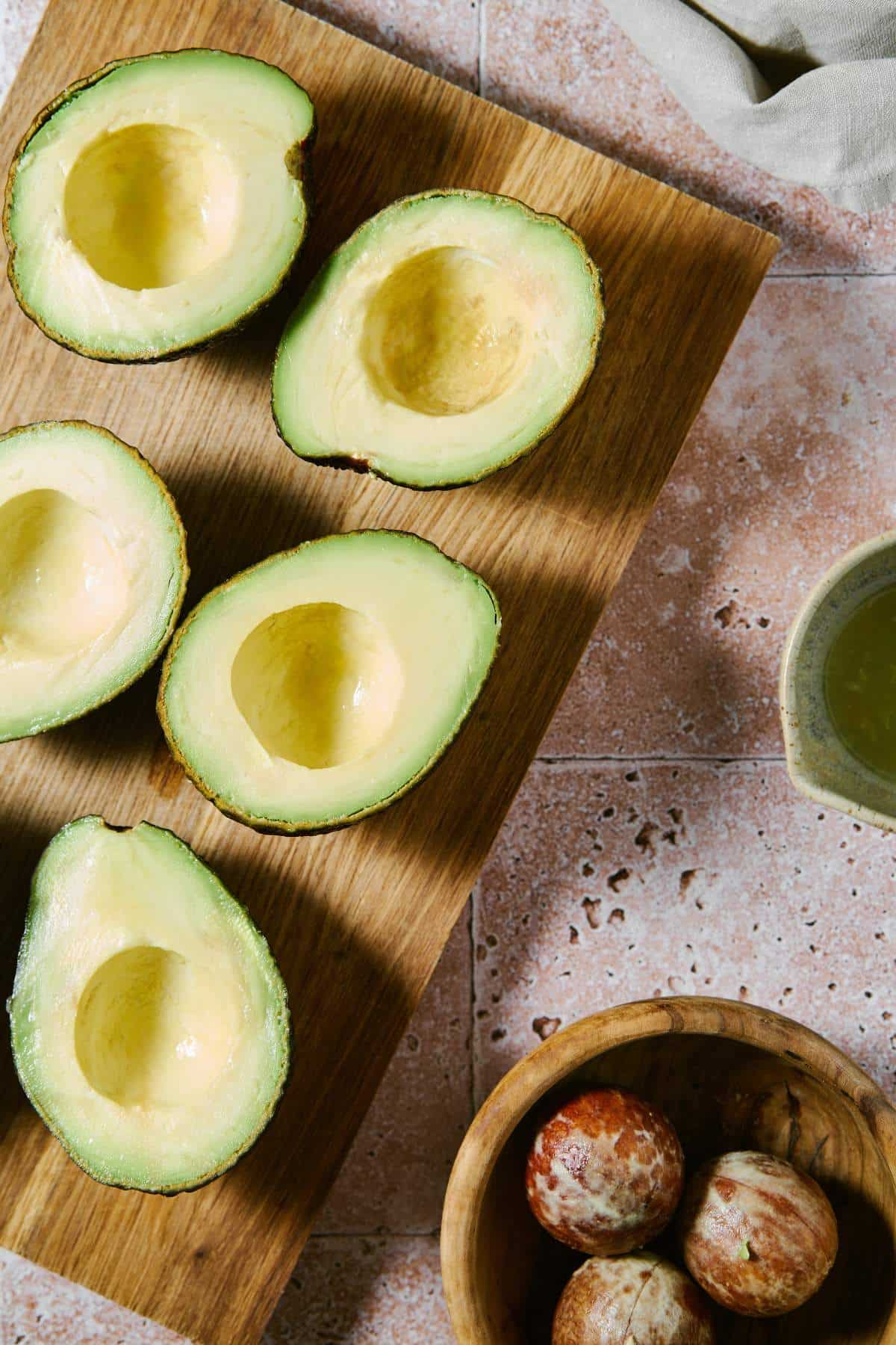 Avocados cut in half on a cutting board.