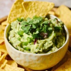 Chipotle guacamole recipe served in a small bowl garnished with fresh cilantro.