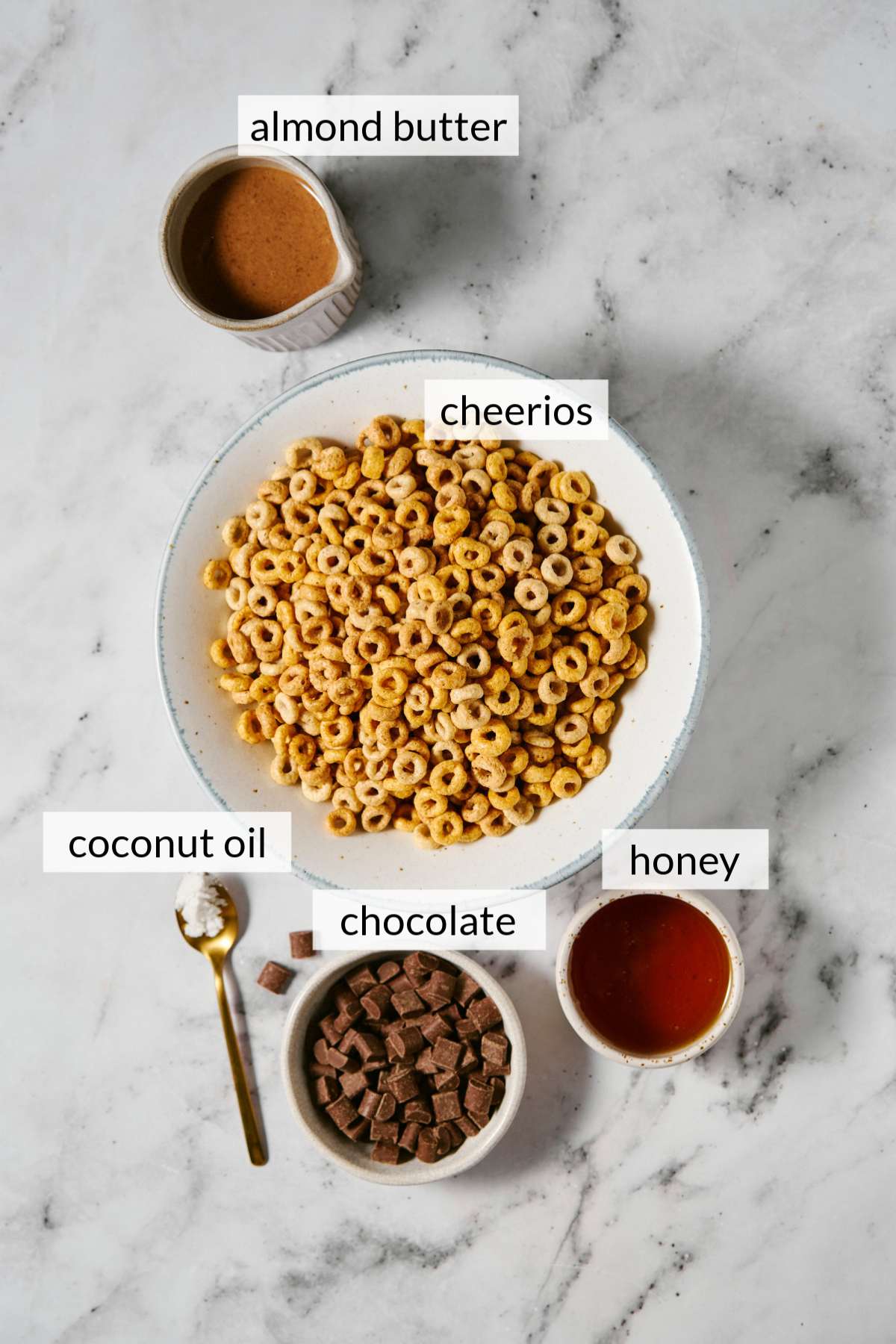 Bowls with Cheerios, almond butter, honey, and chocolate chunks.