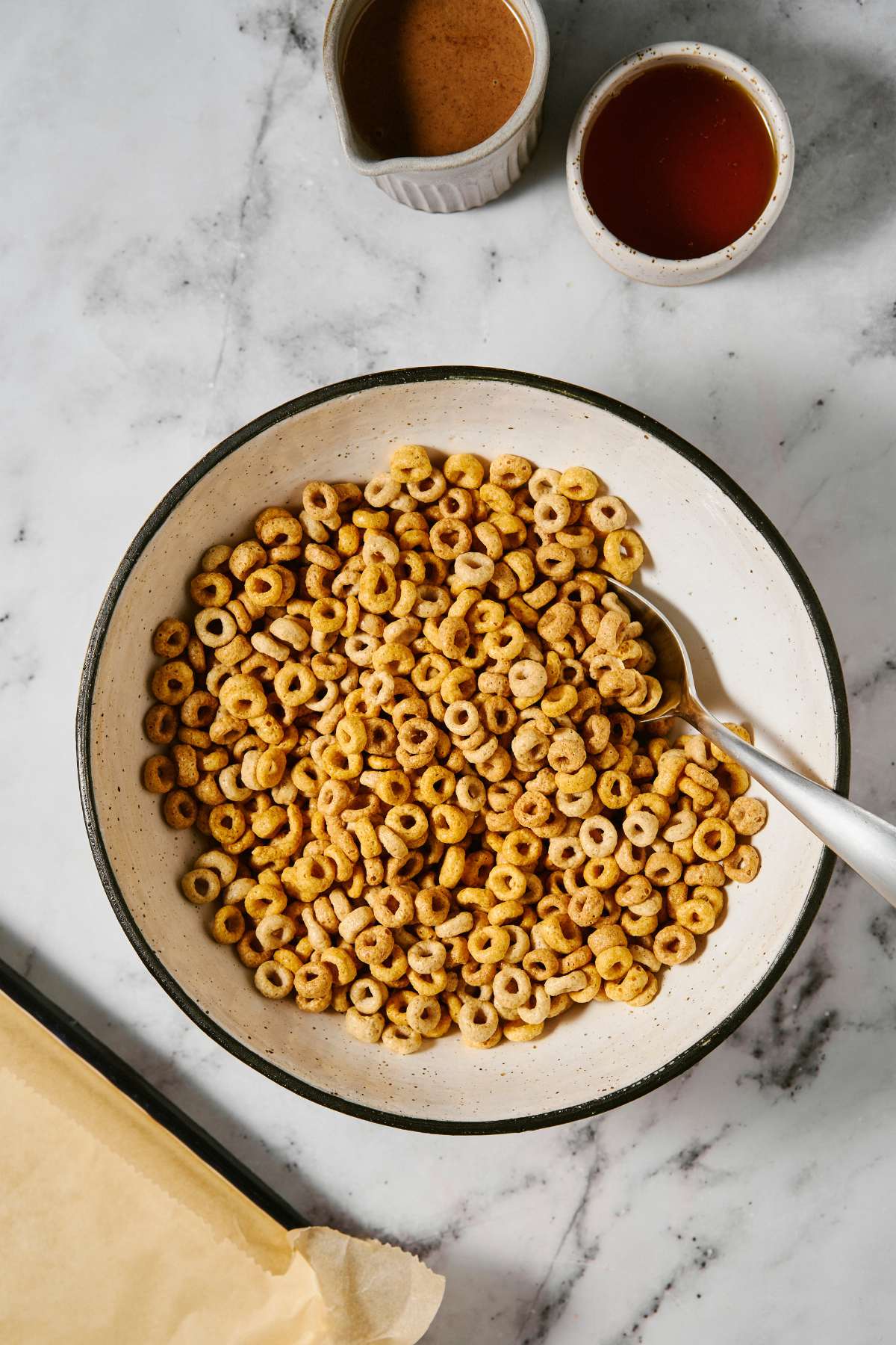 Cheerios poured into a bowl with a spoon.