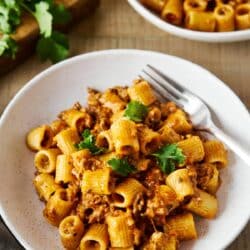 Mexican pasta served in a white bowl with a fork.