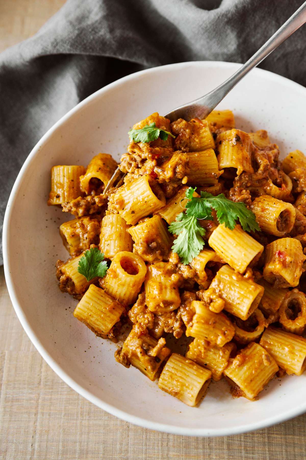 Mexican pasta topped with fresh cilantro in a white bowl.