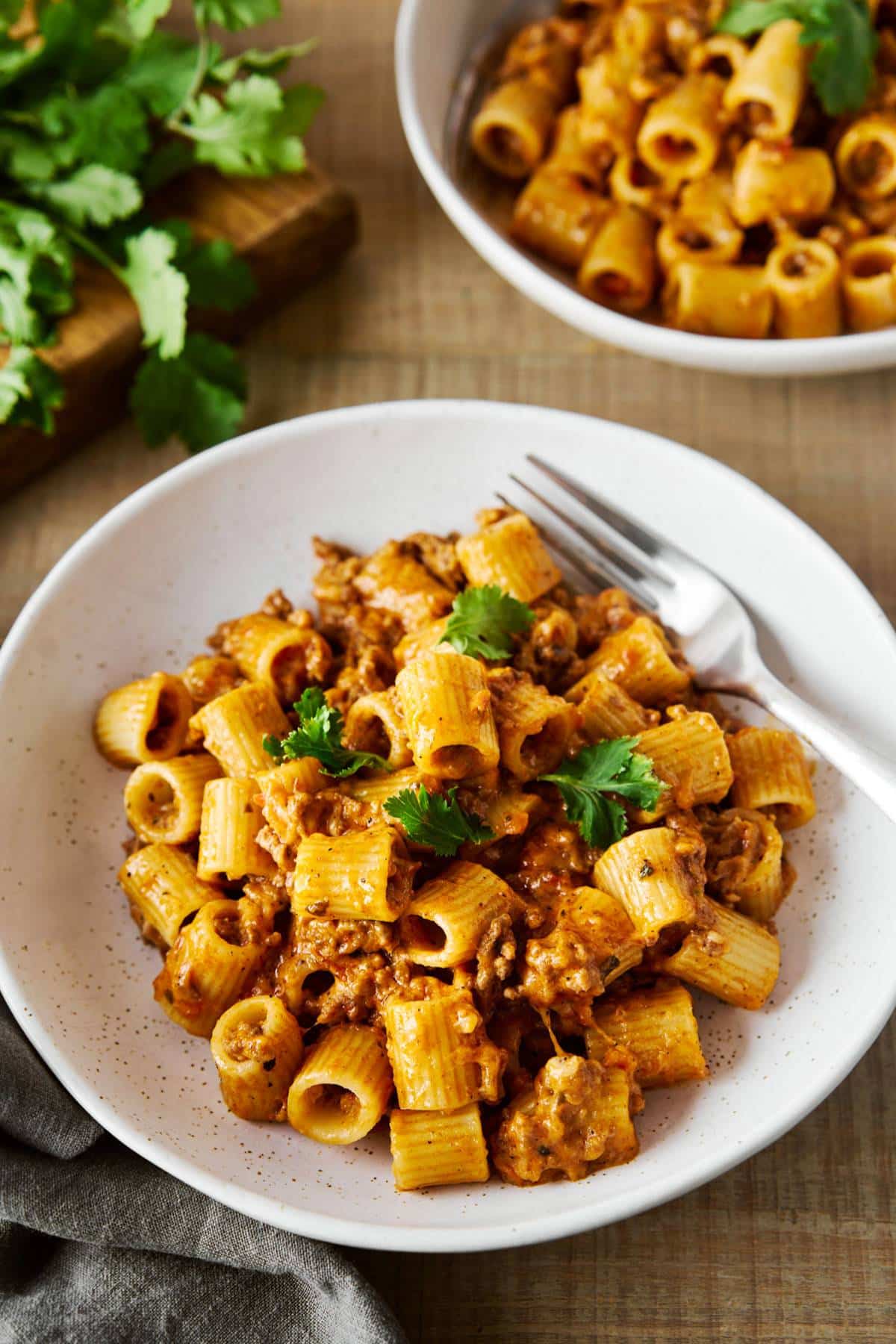 Mexican pasta served in a white bowl with a fork.