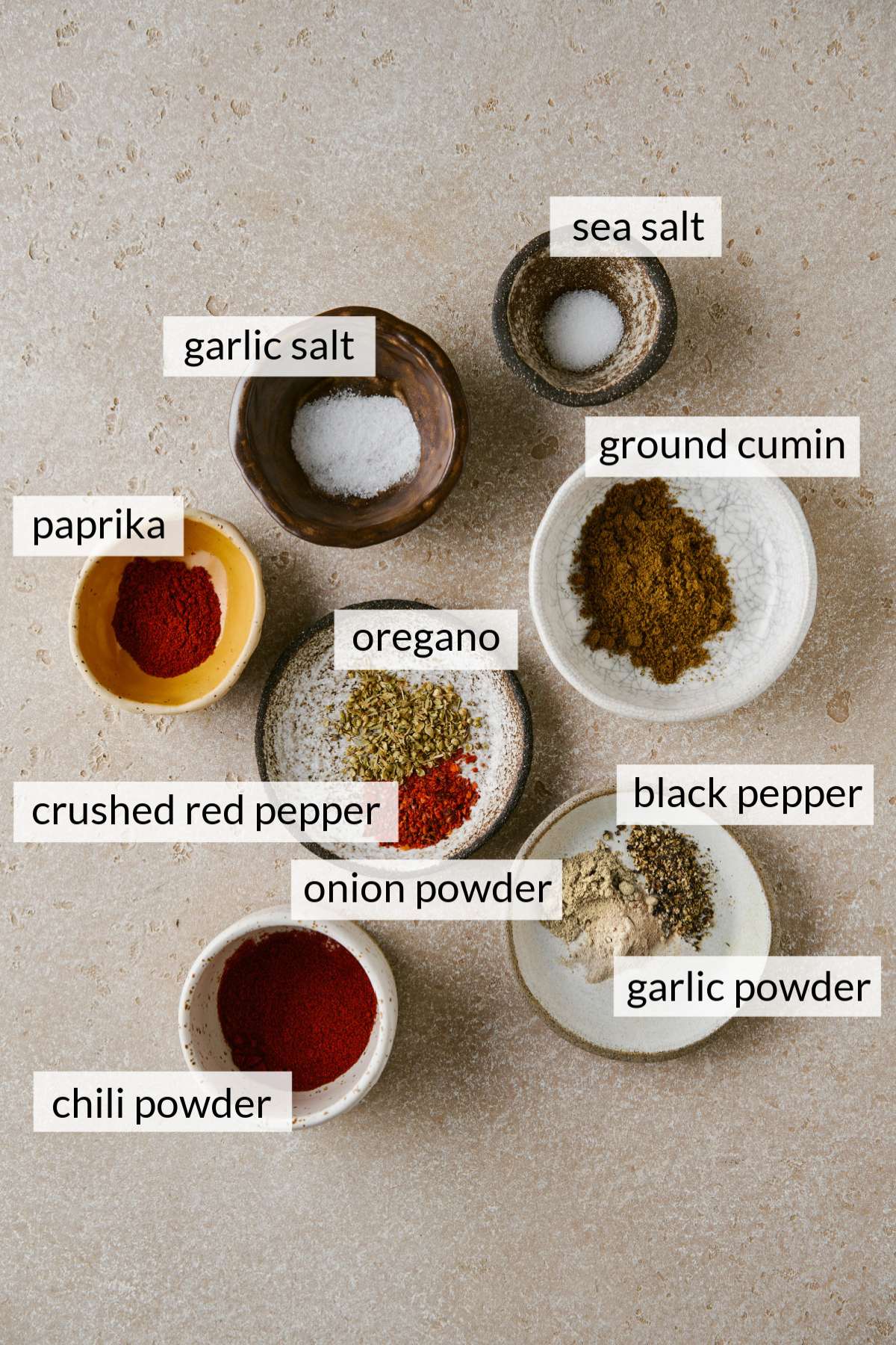 Different seasonings and spices divided into small bowls.