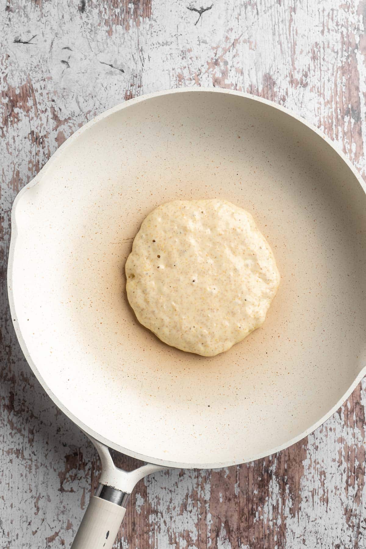 Pancake batter cooking on a large skillet.