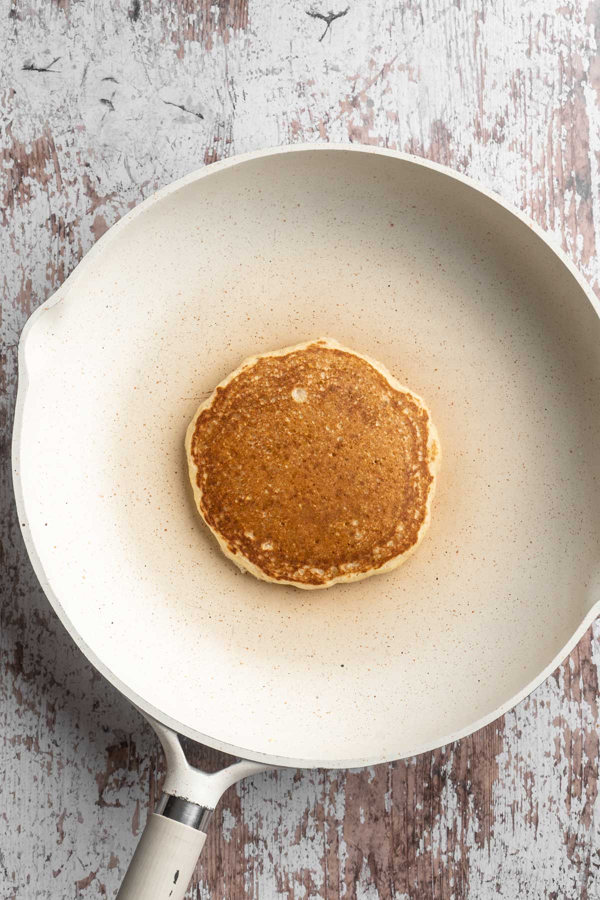 Whole wheat pancake cooking in a pan.