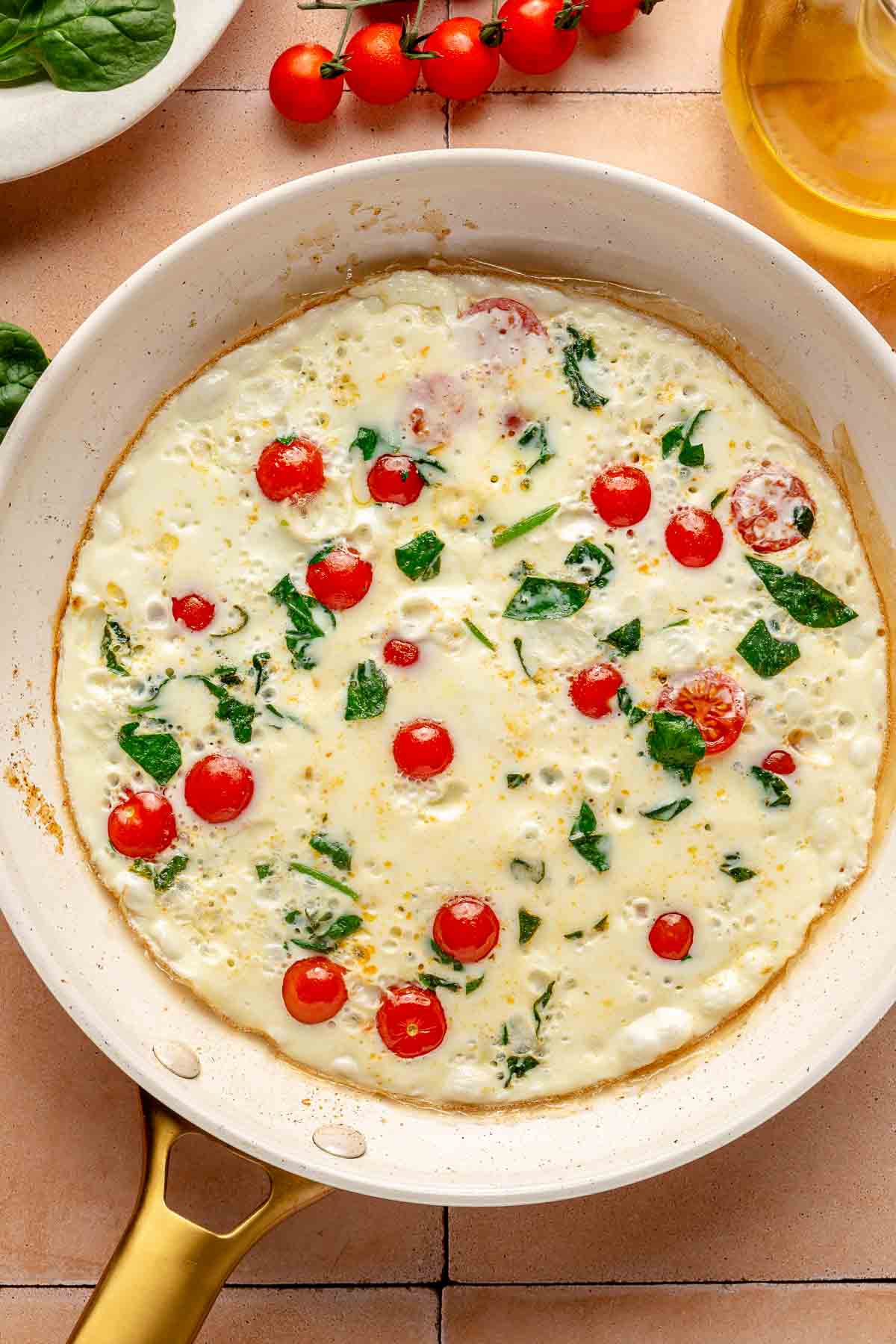 Egg whites set in a pan with tomatoes and spinach.