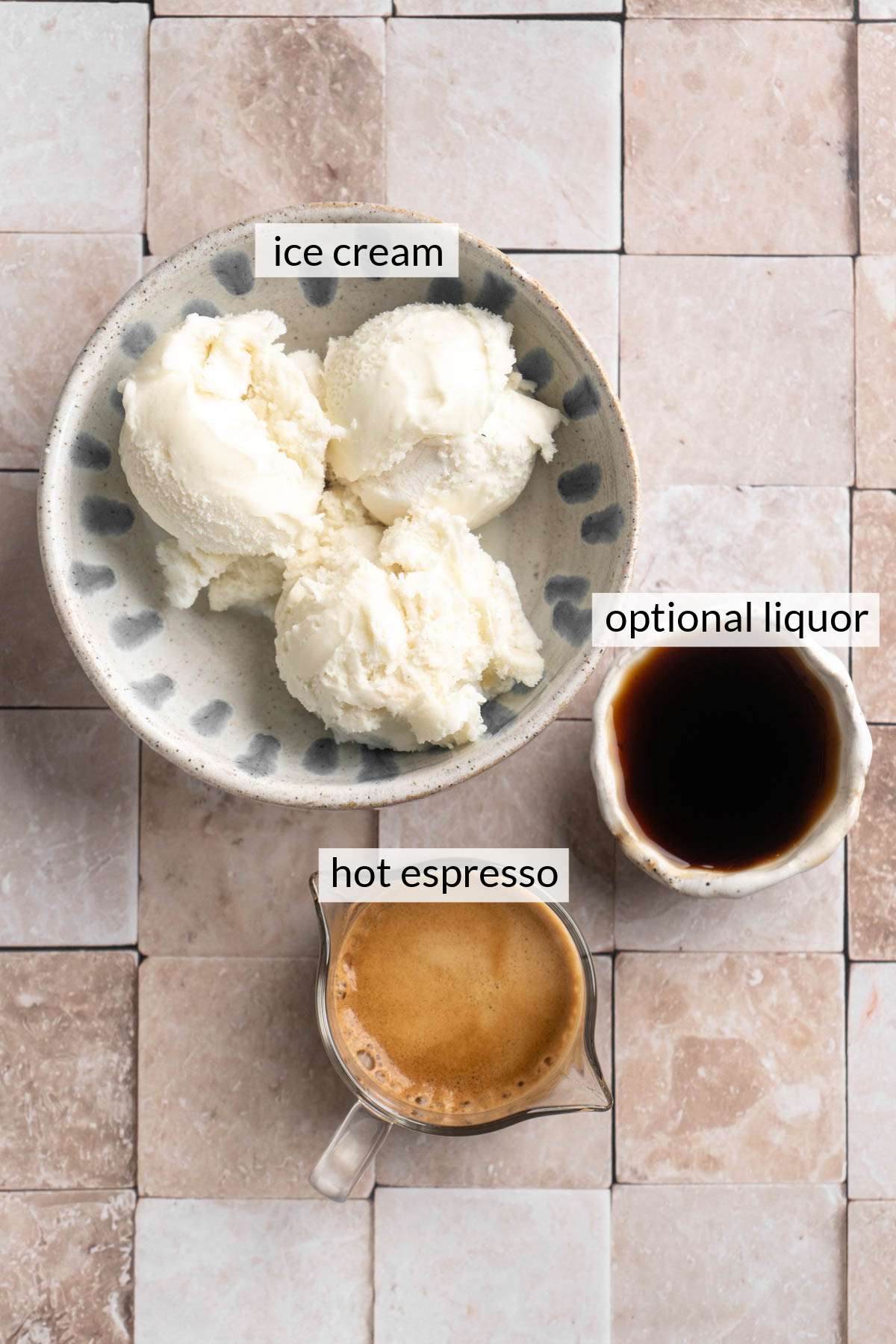 Bowl with scoops of ice cream near a small bowl of liquor and a cup of espresso.