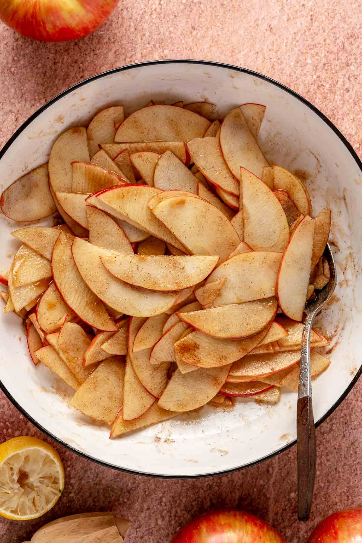 Stirring apple slices with brown sugar, cinnamon and lemon juice.