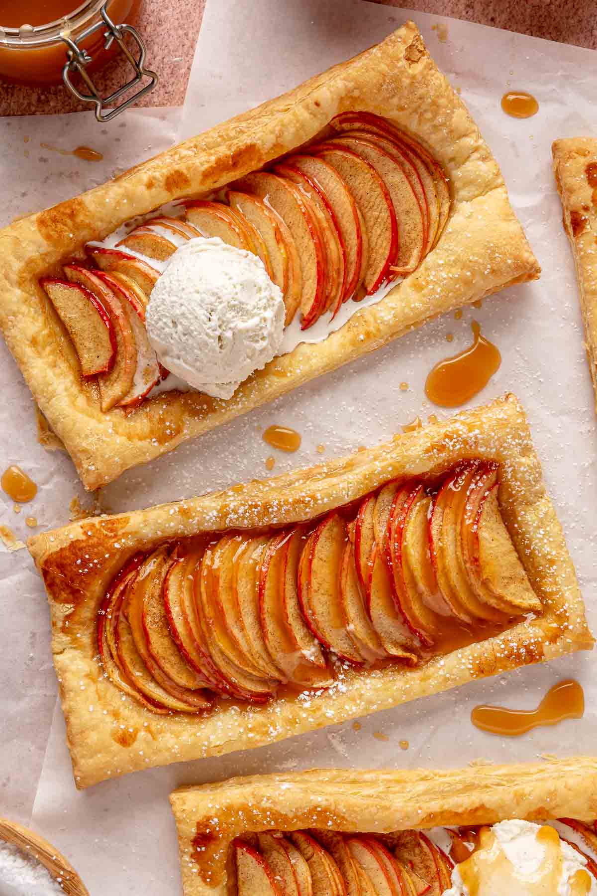 Puff pastry apple tarts topped with a scoop of vanilla ice cream.