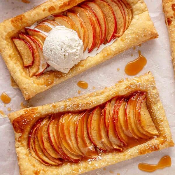 Puff pastry apple tarts topped with a scoop of vanilla ice cream.