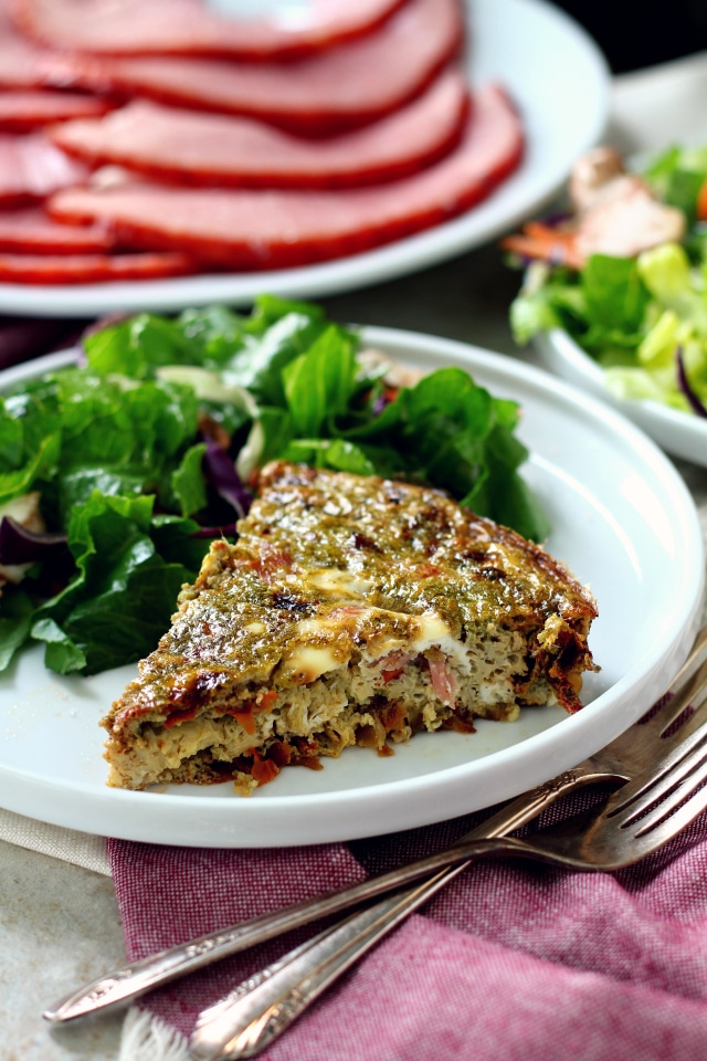 Sun-Dried Tomato Pesto Ham Frittata on a white plate with a green salad