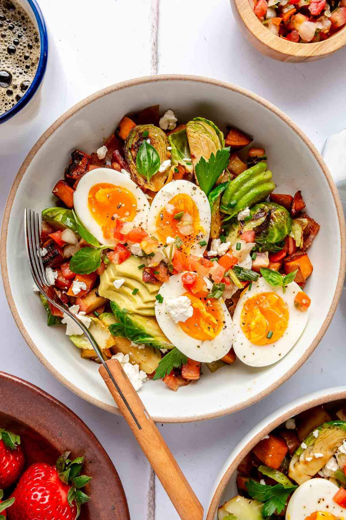 Breakfast bowl with a hard boiled egg, avocado and sweet potato hash.