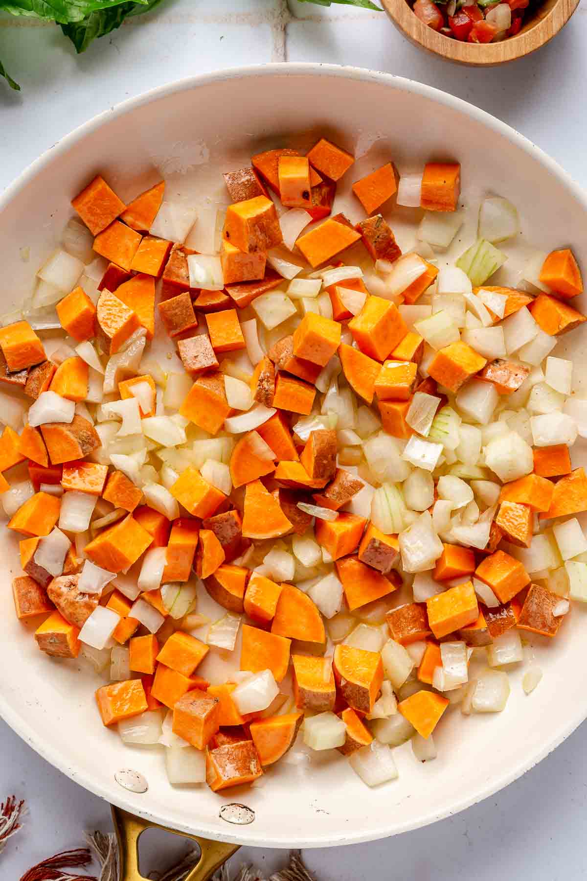 Sautéing onion and sweet potato in a large skillet.