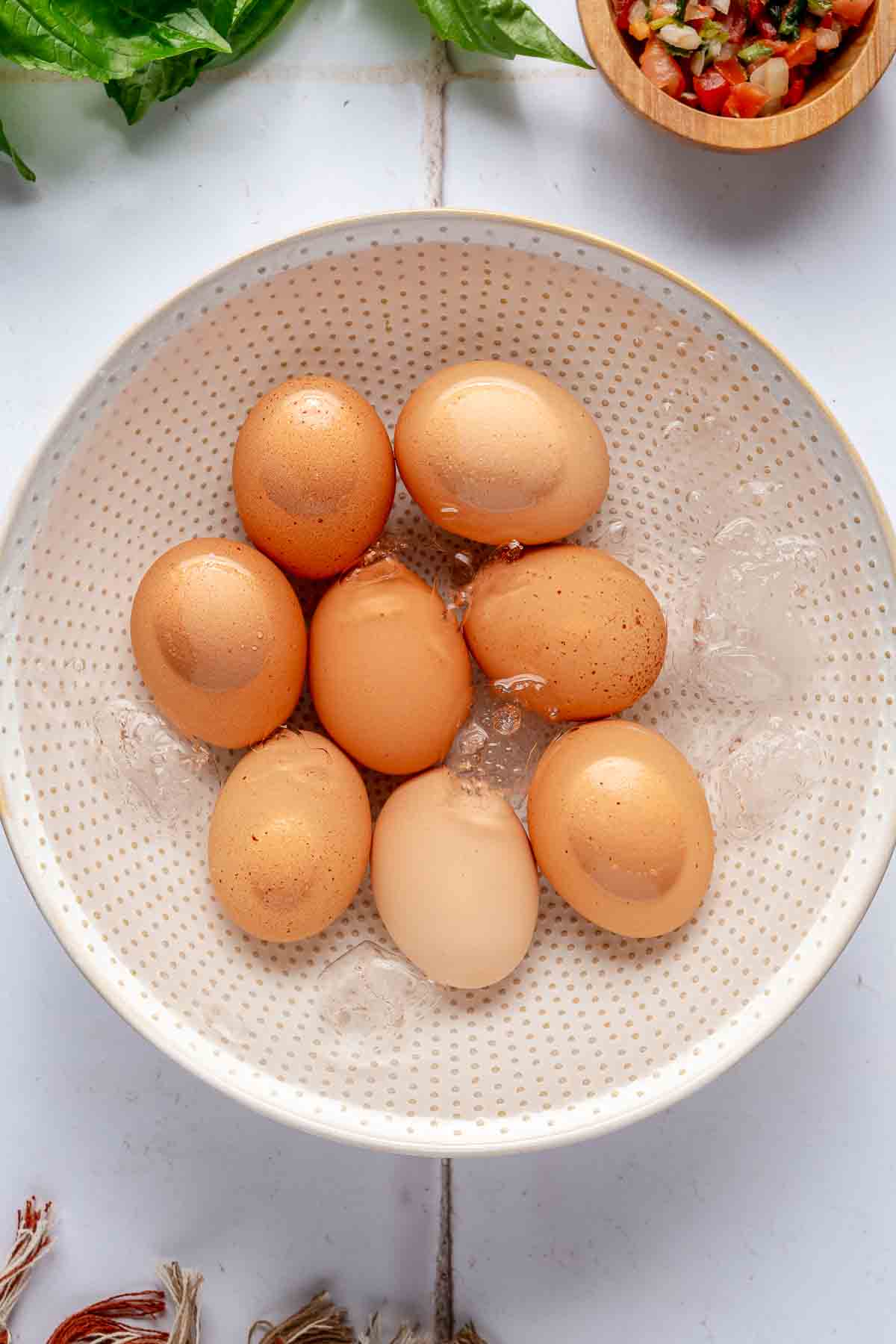 Hard-boiled eggs in a bowl filled with ice water.