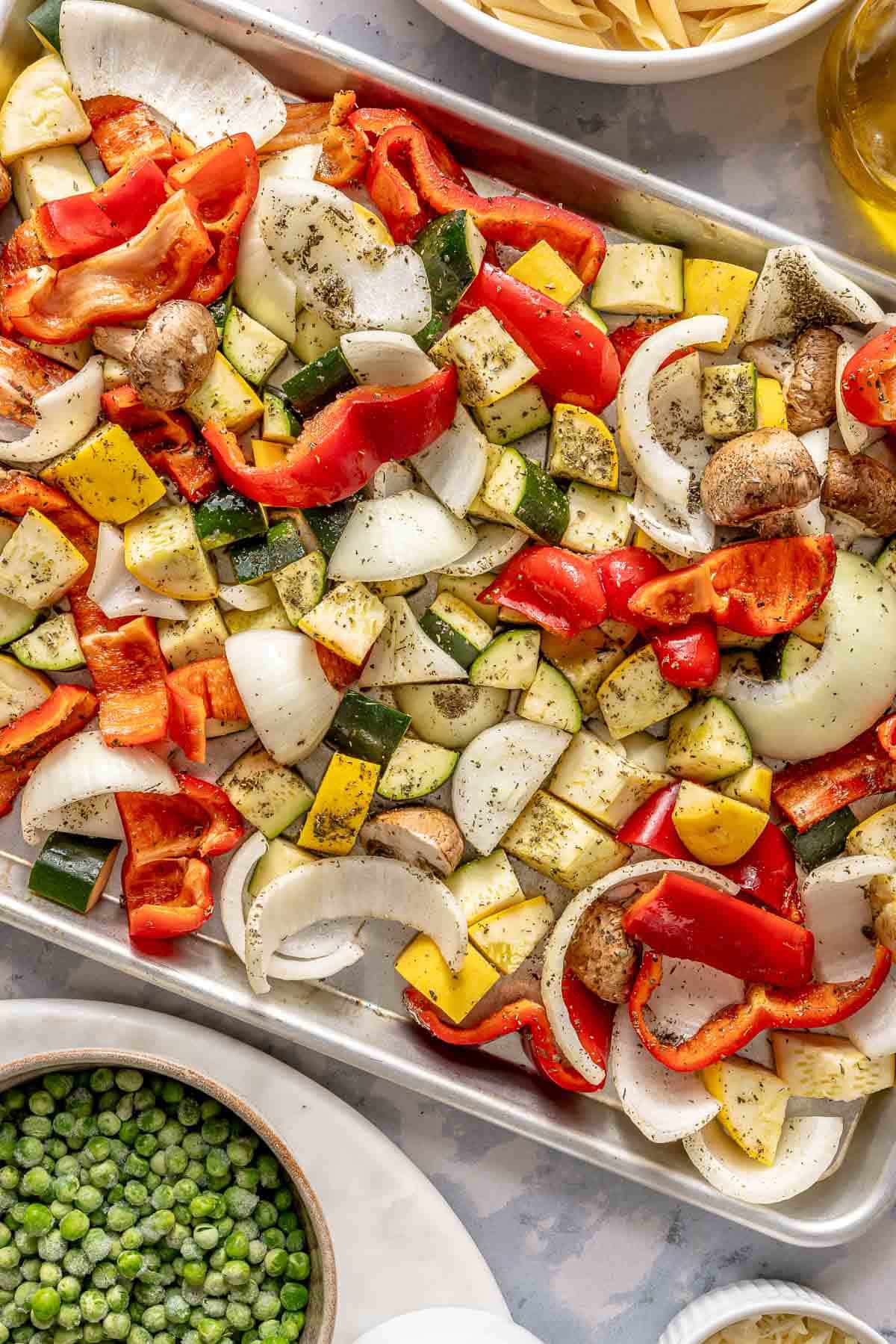 Seasoned vegetables on a baking sheet.