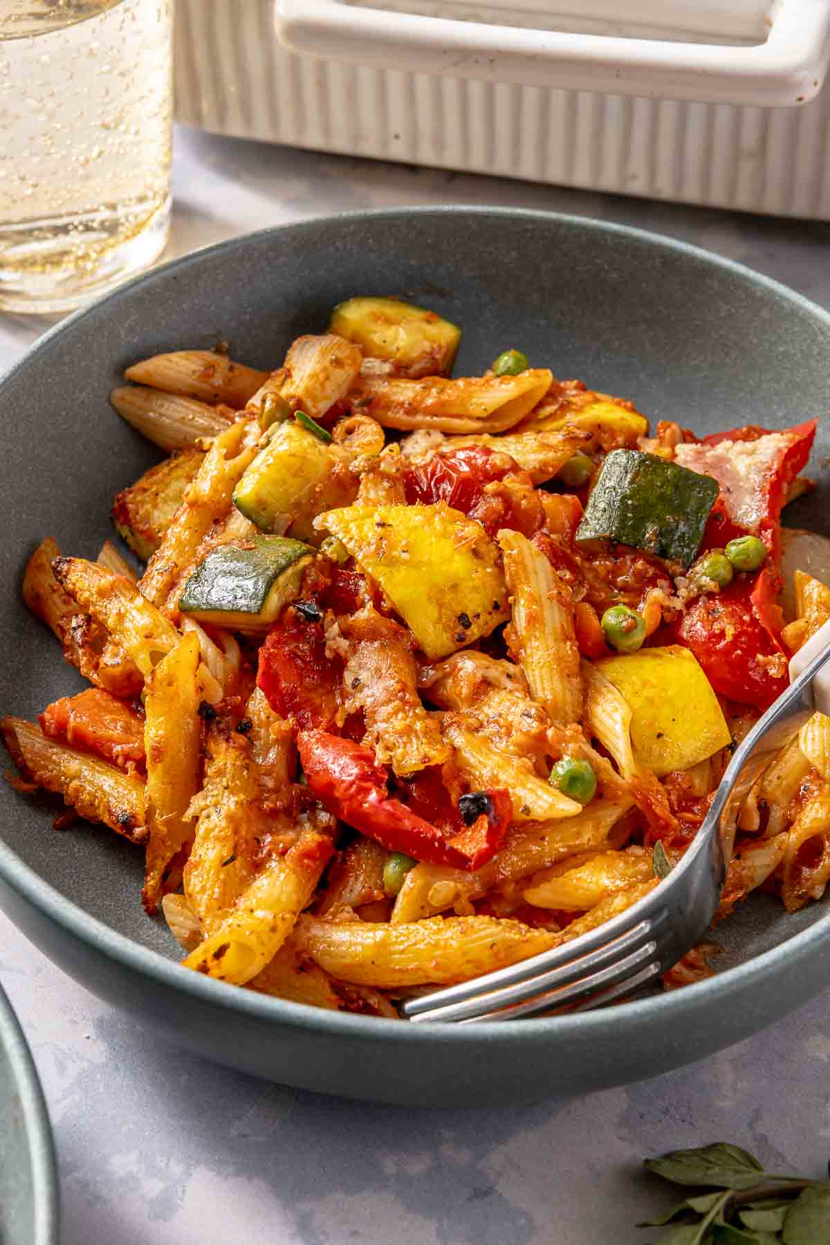 Vegetable pasta served in a bowl with a fork.