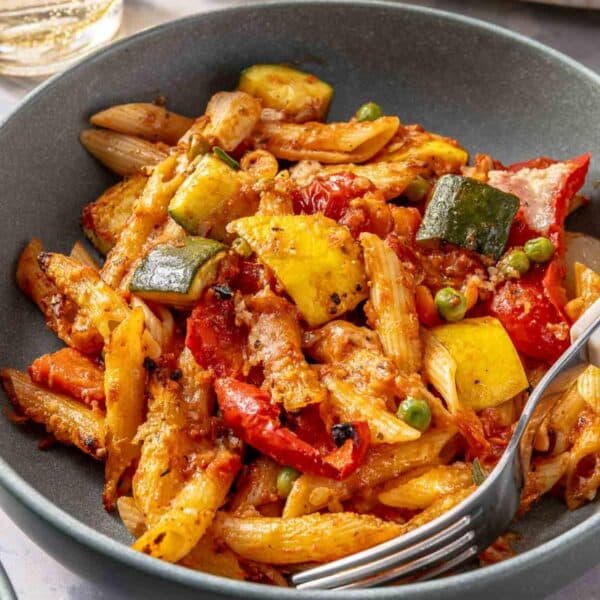 Vegetable pasta served in a bowl with a fork.