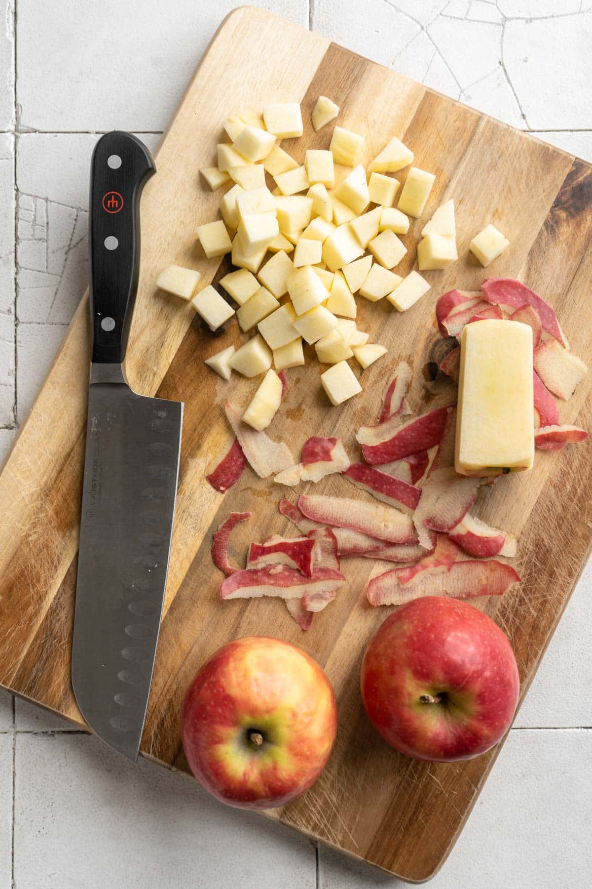 Diced apple near a knife on a cutting board.