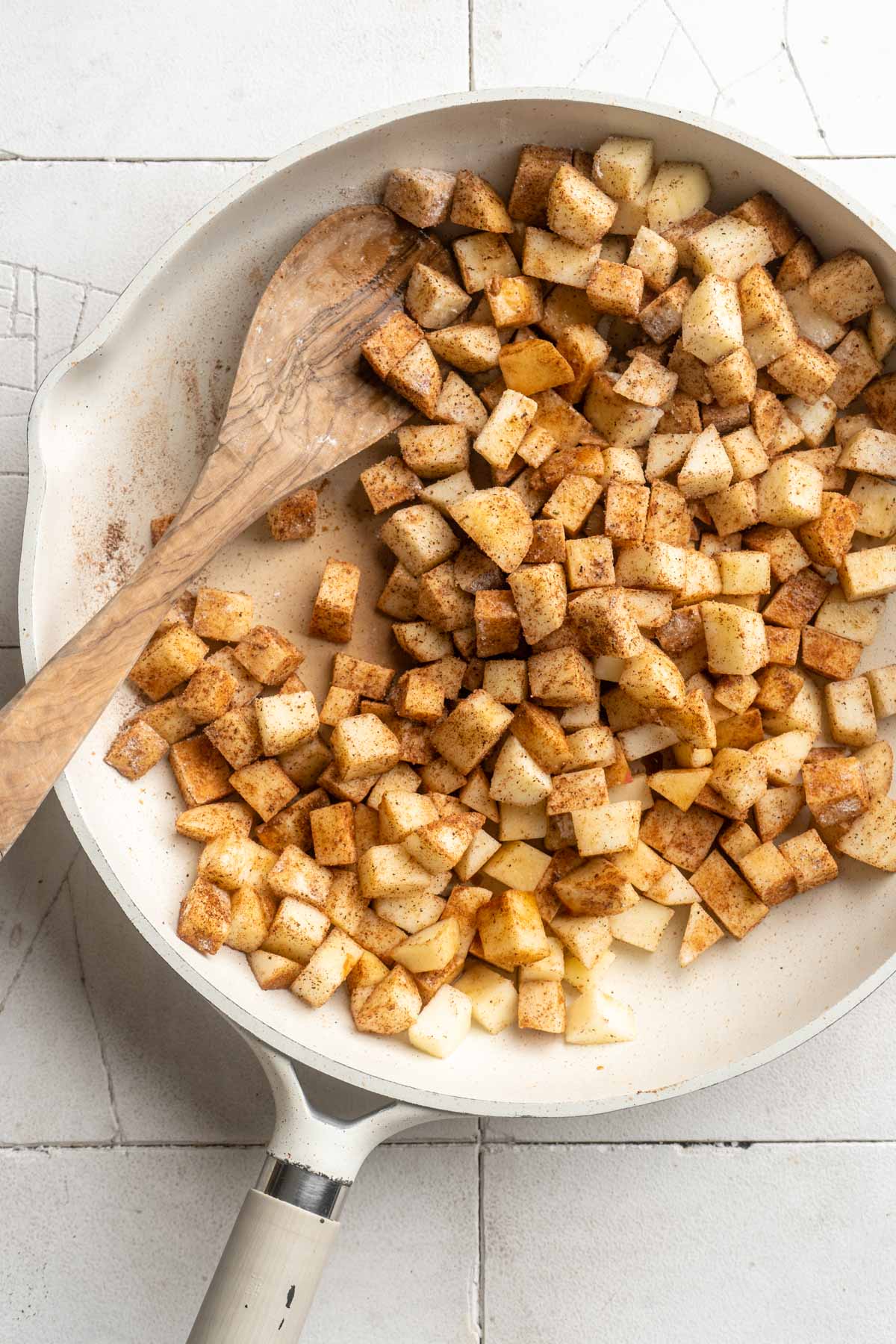 Stirring diced apples with spices in a pan. 