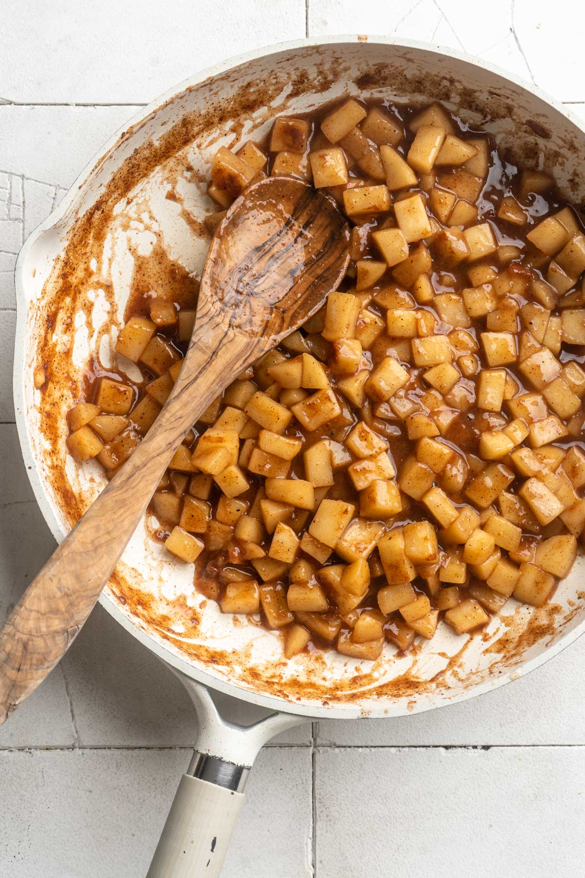 Wooden spoon in a skillet with homemade apple pie filling.