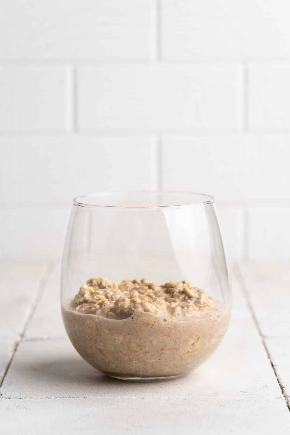 Oat and milk mixture in the bottom of a glass.