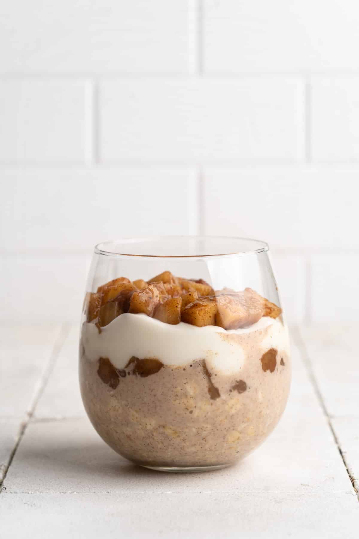 Apple cinnamon overnight oats in a short glass.