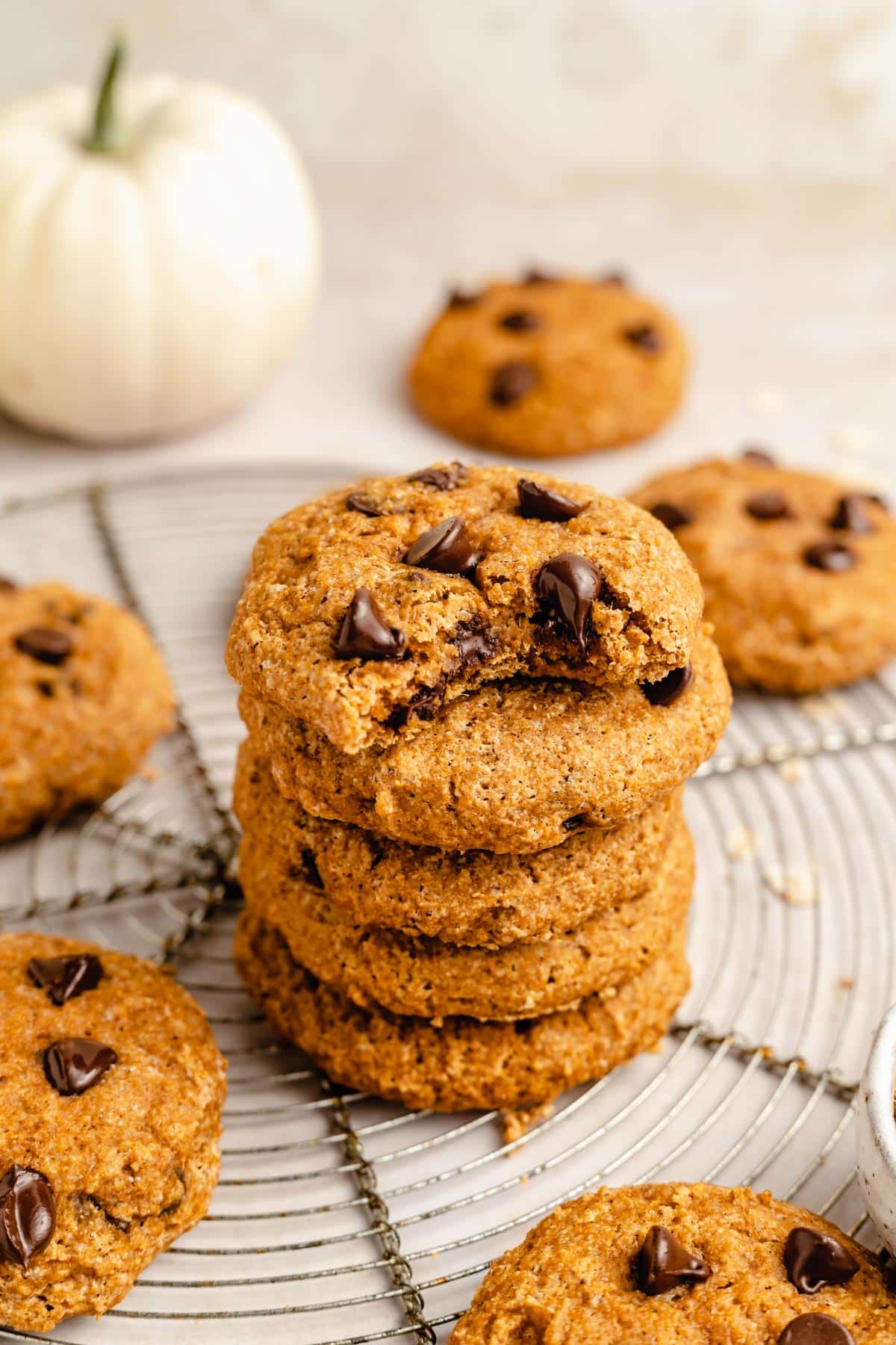 pumpkin cookies stacked on a wire cooling rack