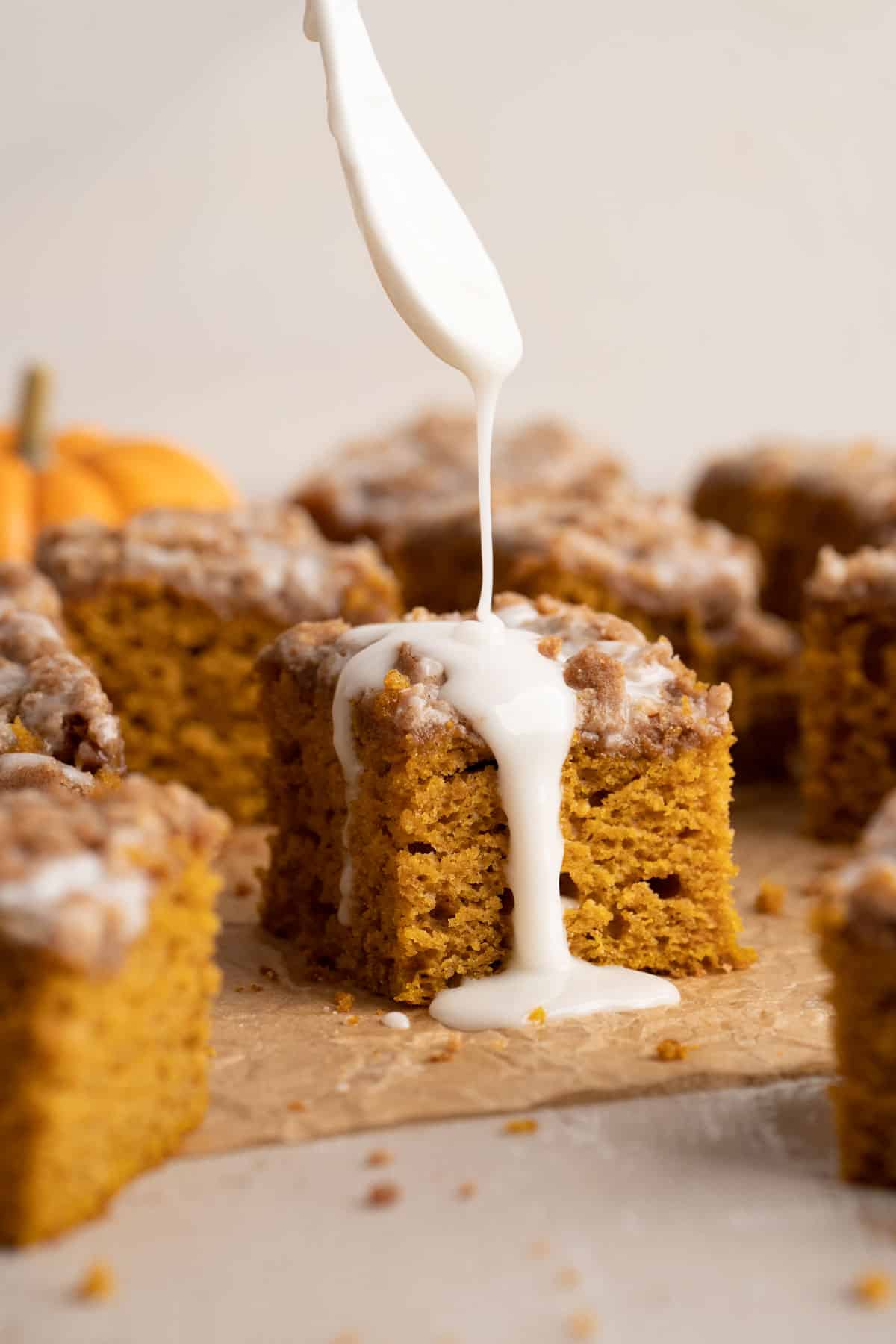 Drizzling pumpkin coffee cake with icing.