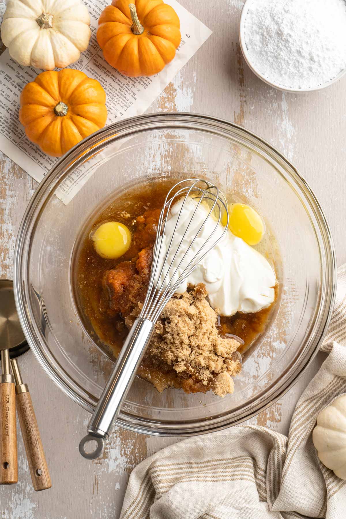 Combining pumpkin with yogurt, eggs and brown sugar in a large bowl.