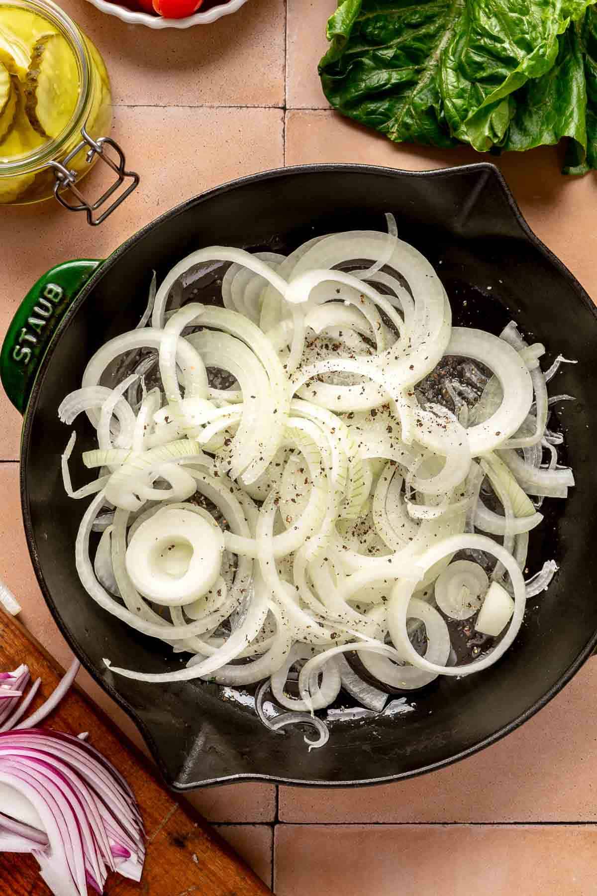 Cooking sliced onion in a cast-iron pan.