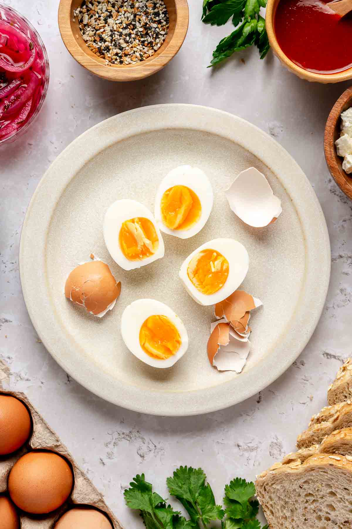 Hard boiled eggs cut in half on a white plate.