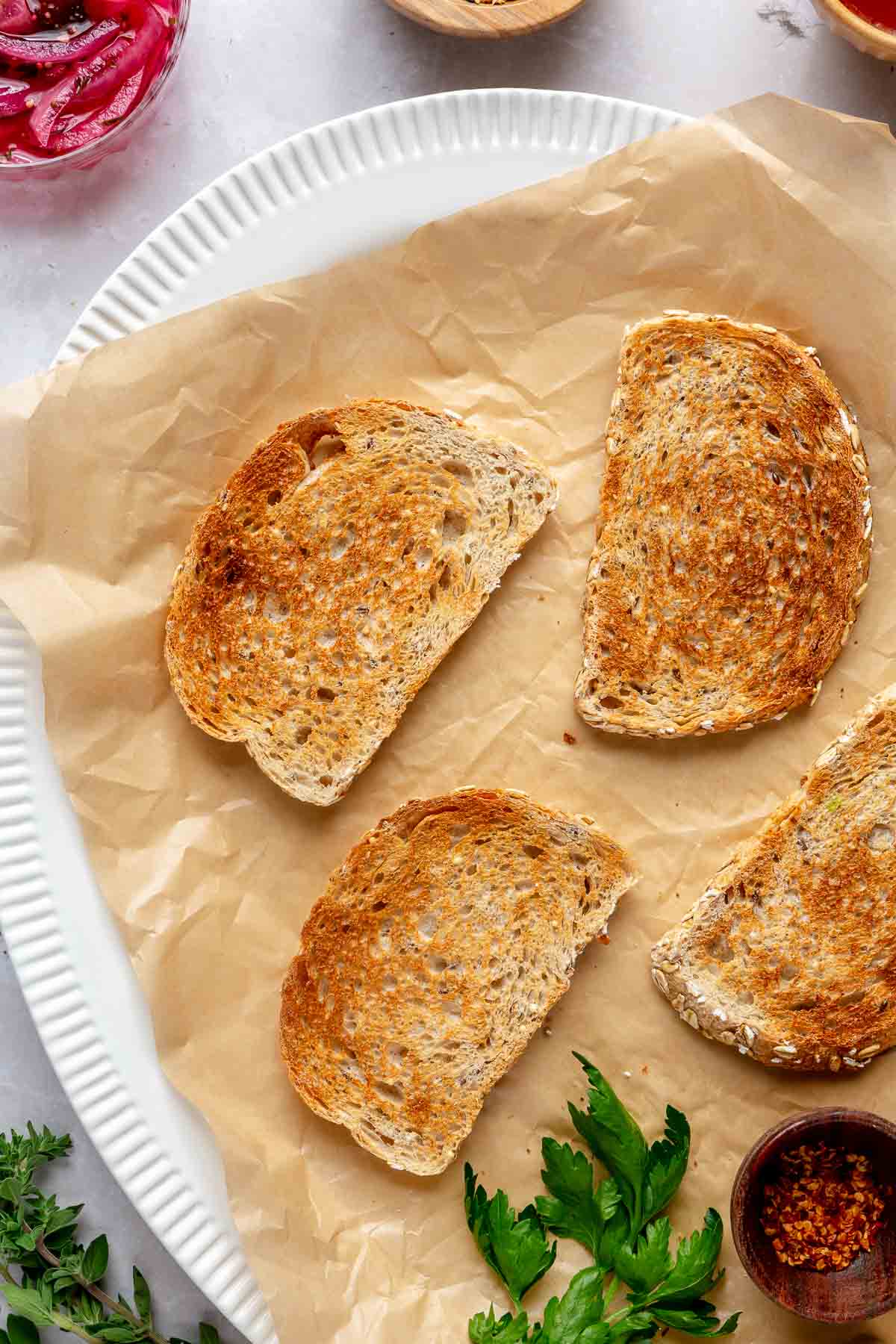 Toasted slices of bread on parchment paper.